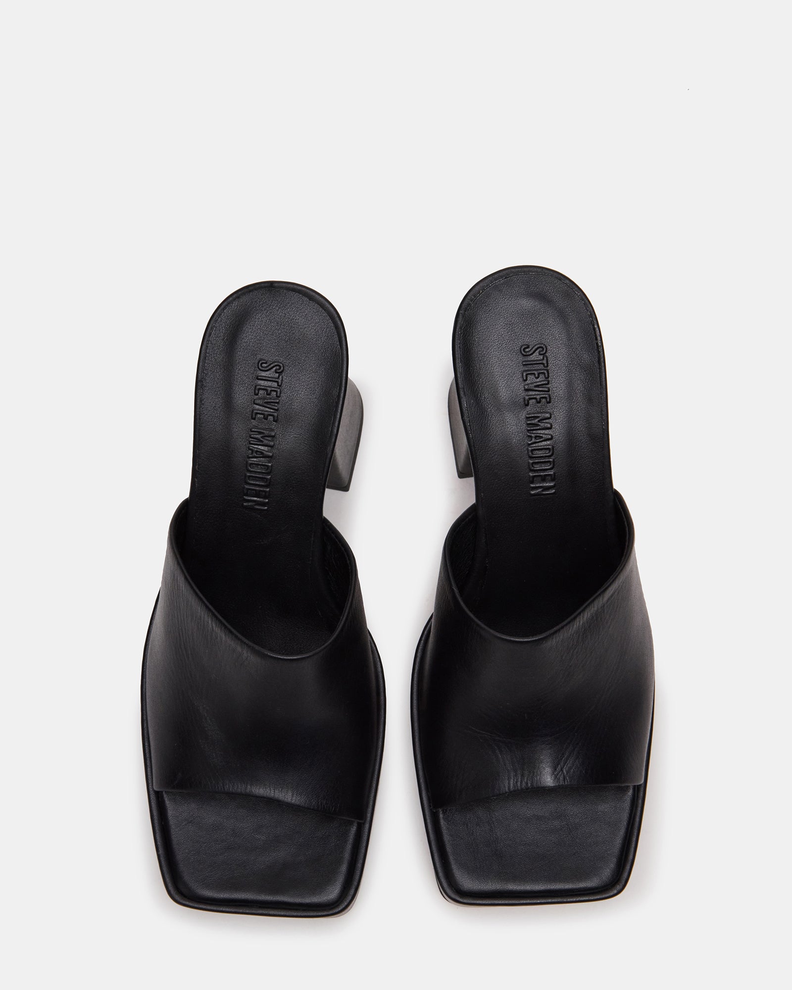 Black leather mule with square toe and block heel on a stylish woman