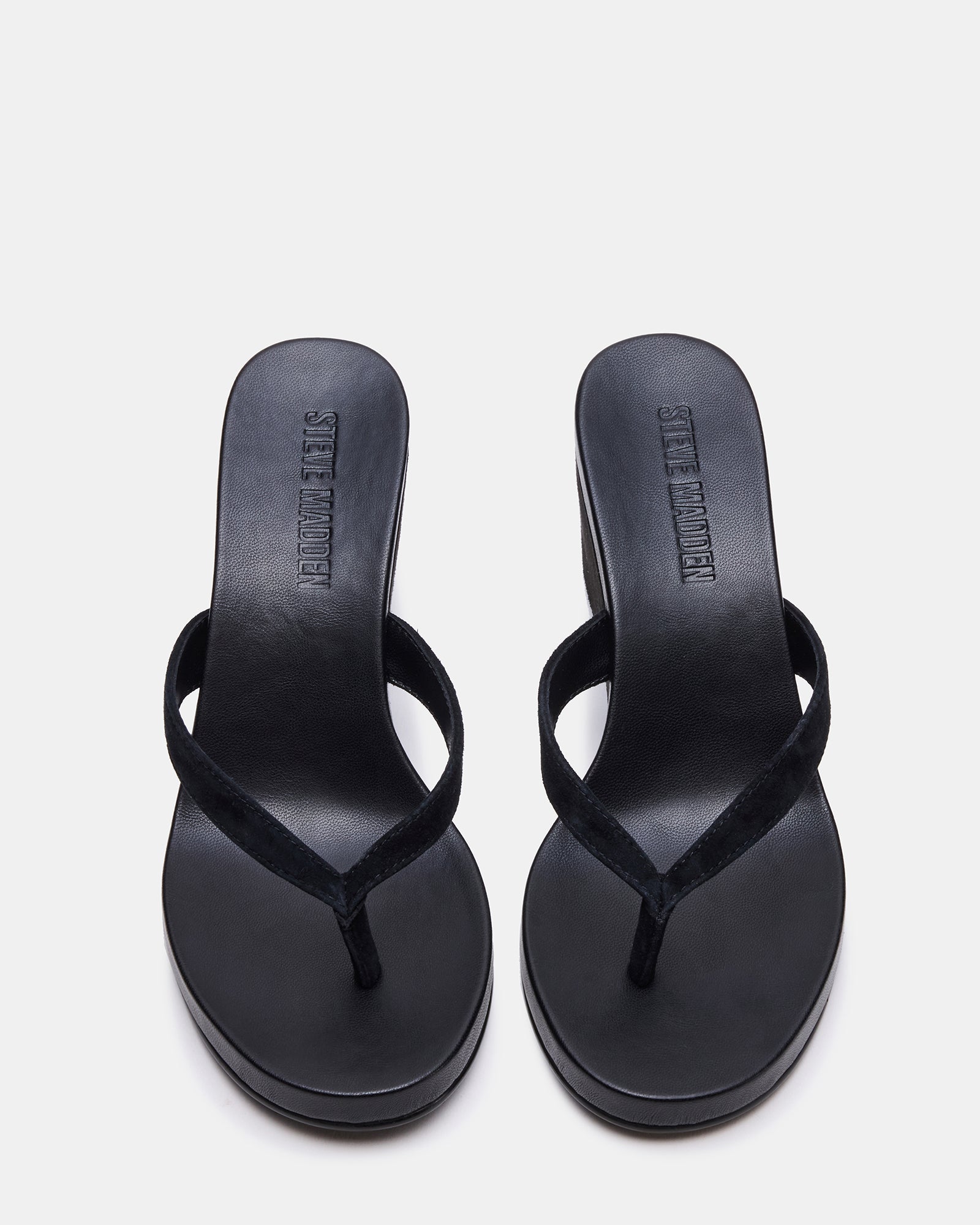 Side view of the black suede wedge sandal showing the 3-inch heel and sleek design