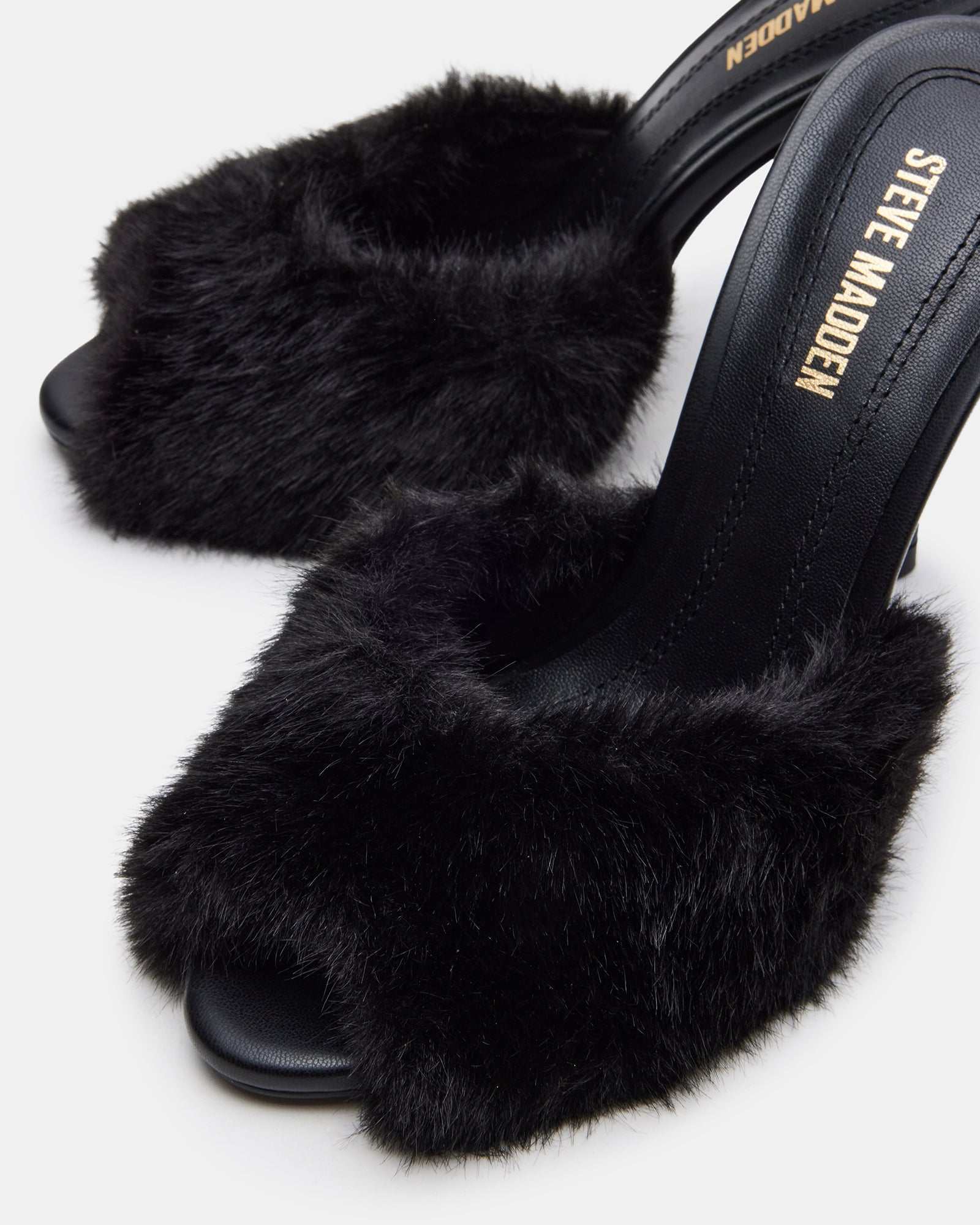 Close-up side view of faux fur sandals highlighting the stiletto heel