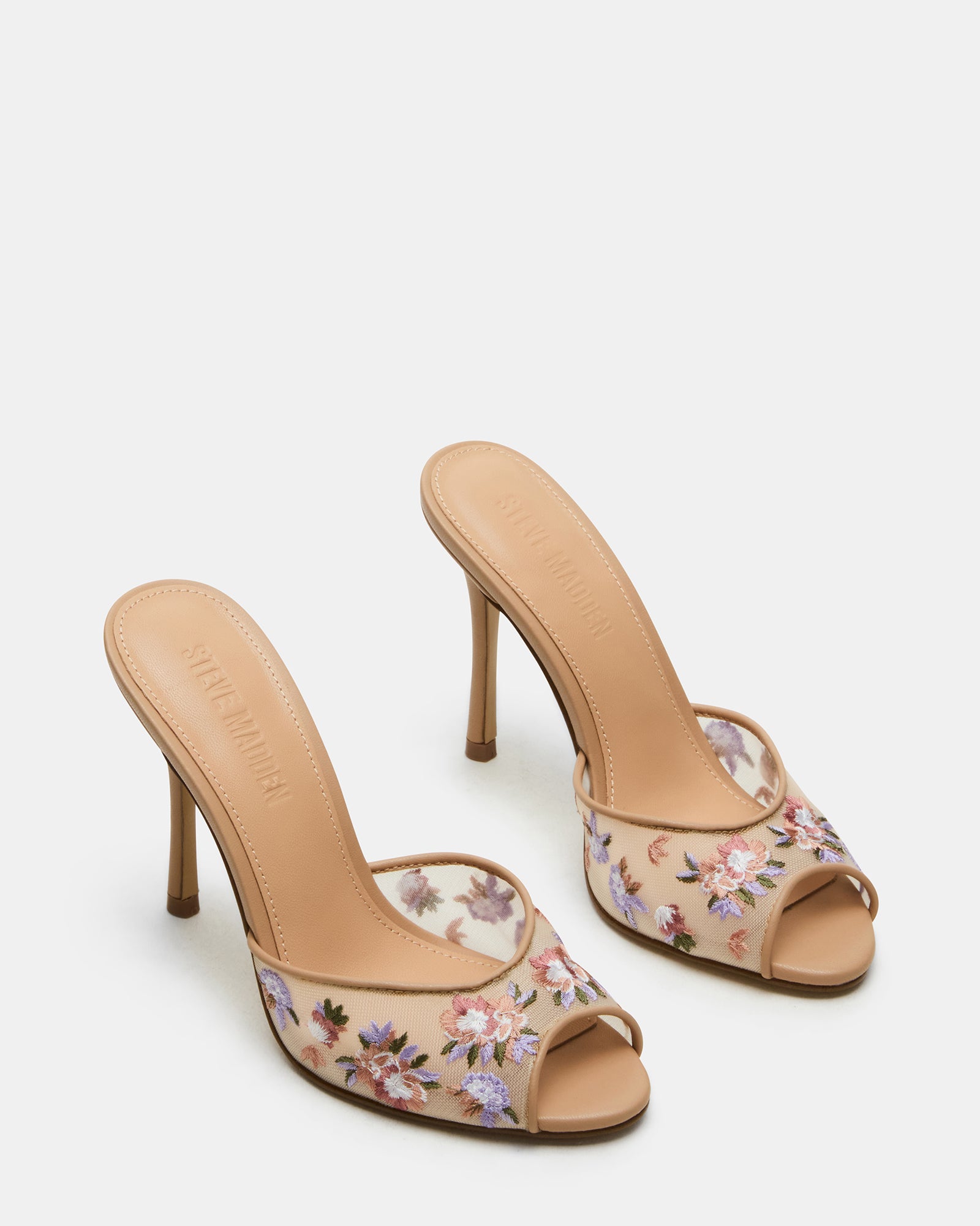 Stylish nude high heel sandals worn at a summer event