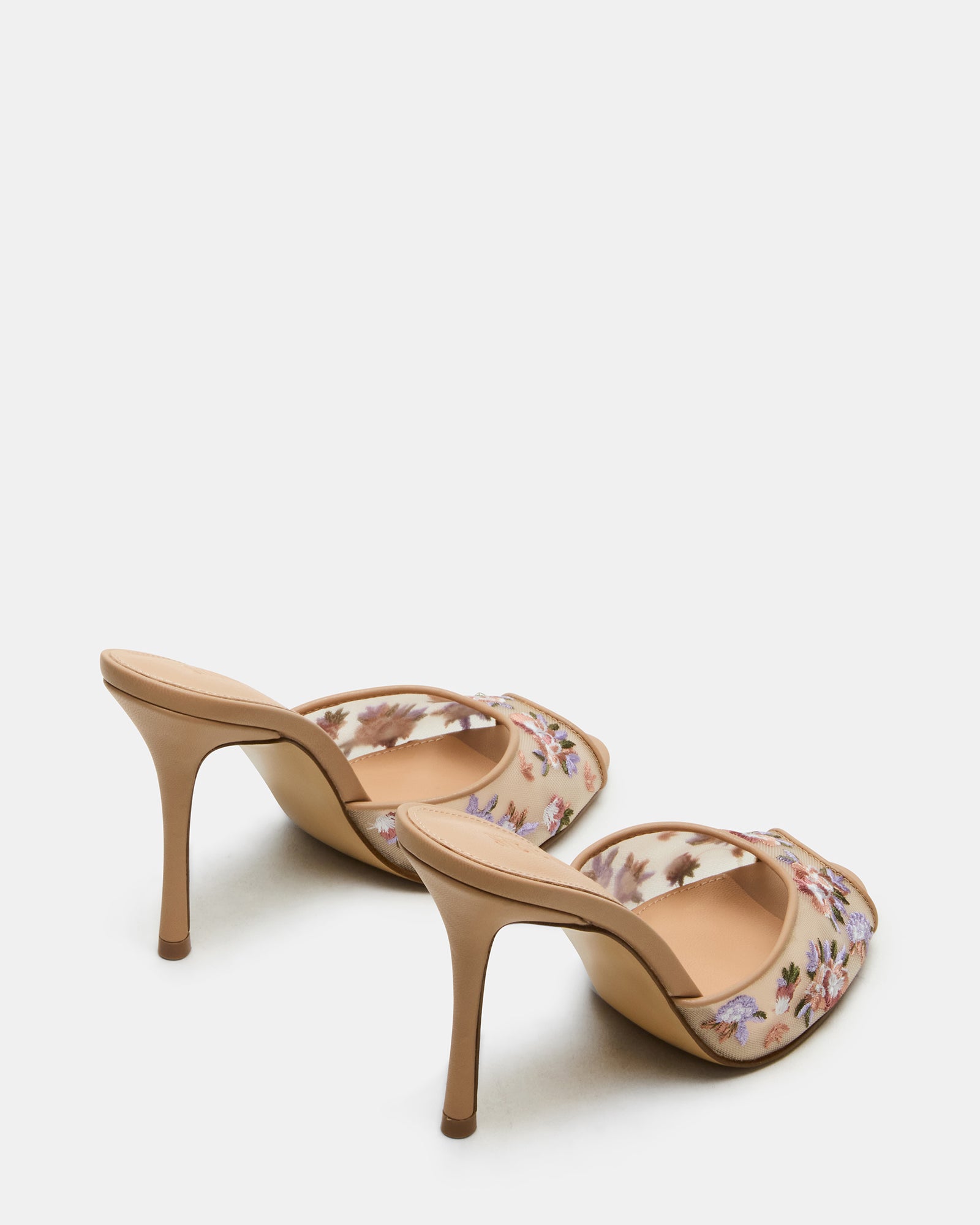 Stylish nude high heel sandals worn at a summer event