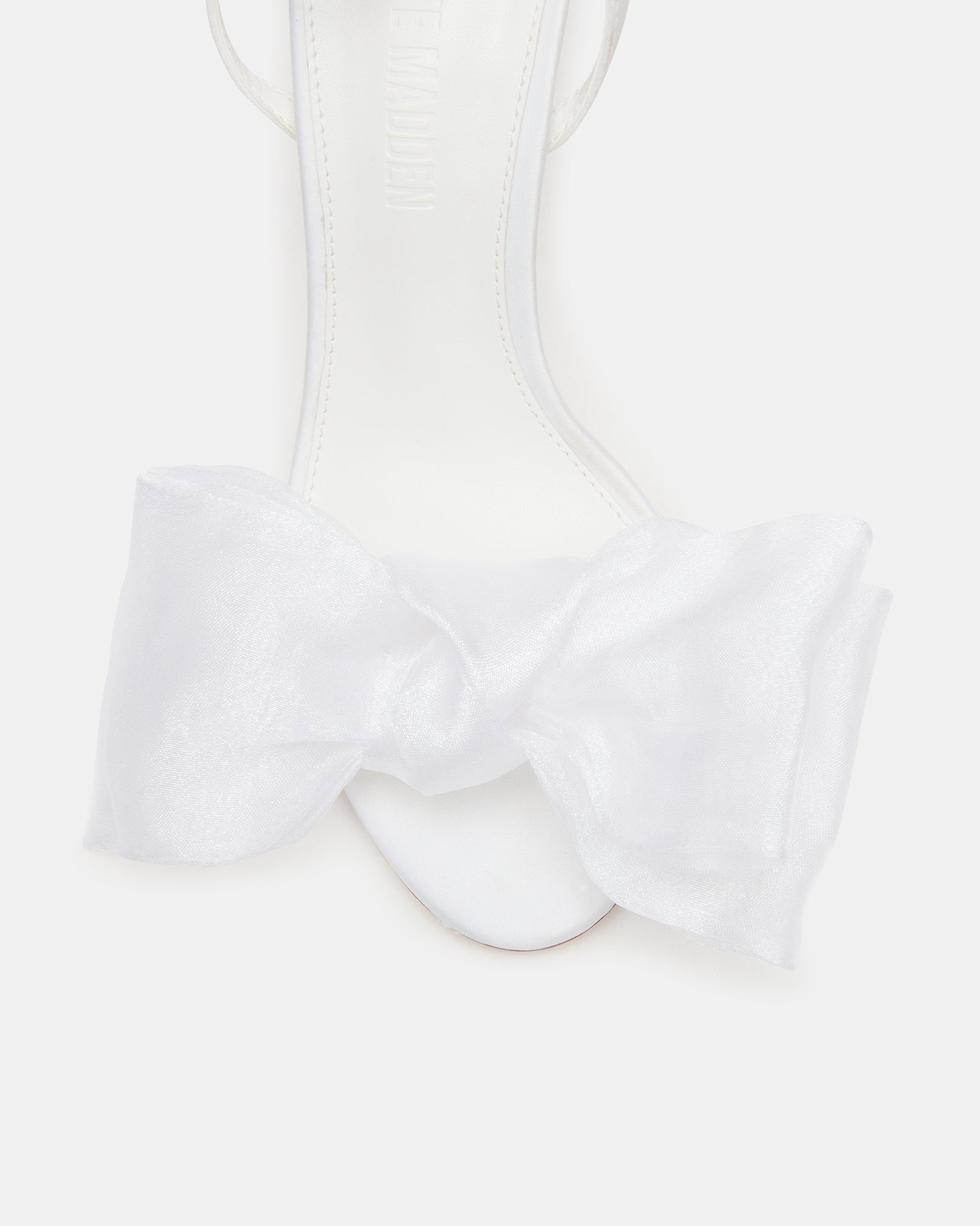 Close-up of strappy black heels versus white variant for comparison