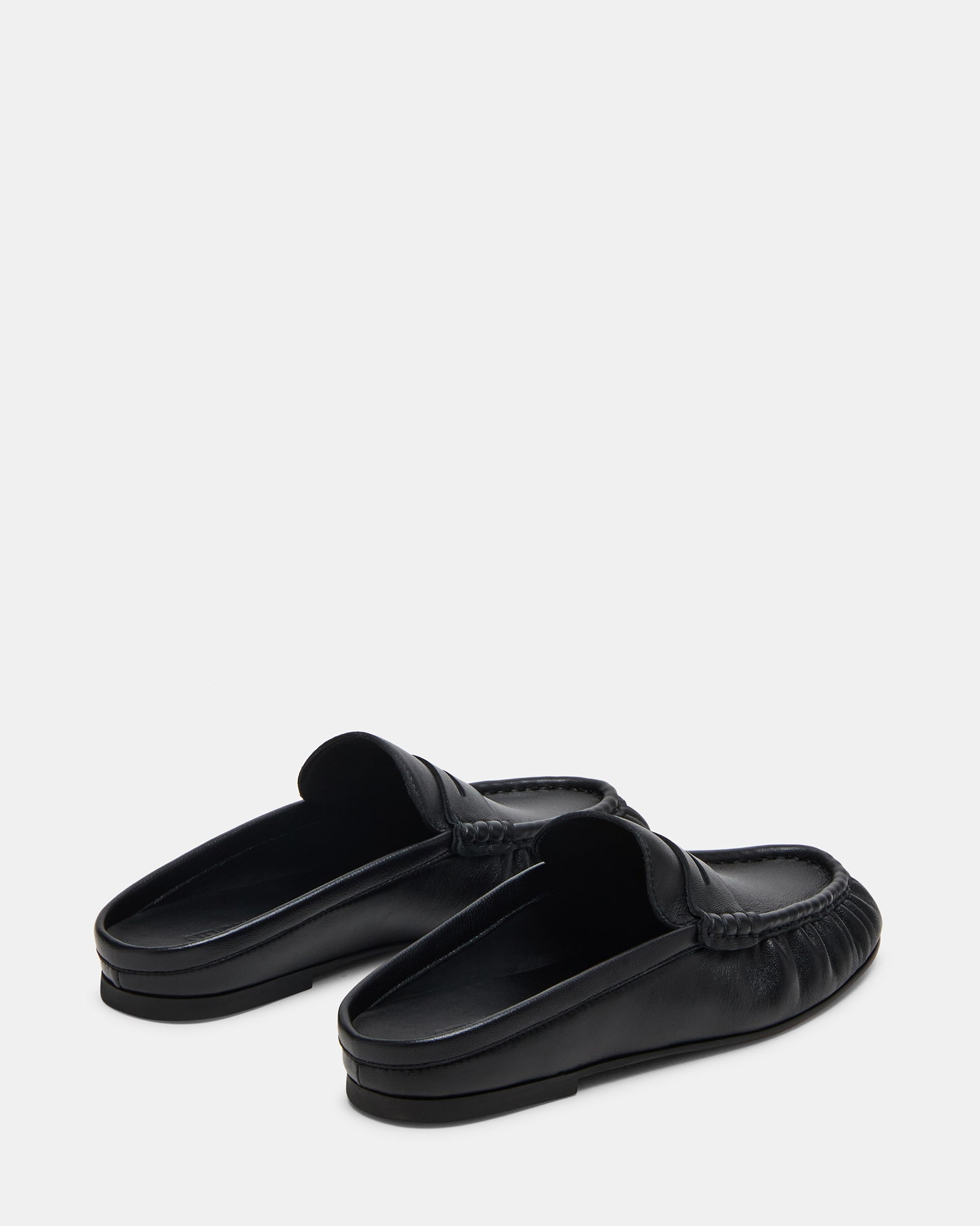 Side angle of slip-on black leather flats showing comfort features
