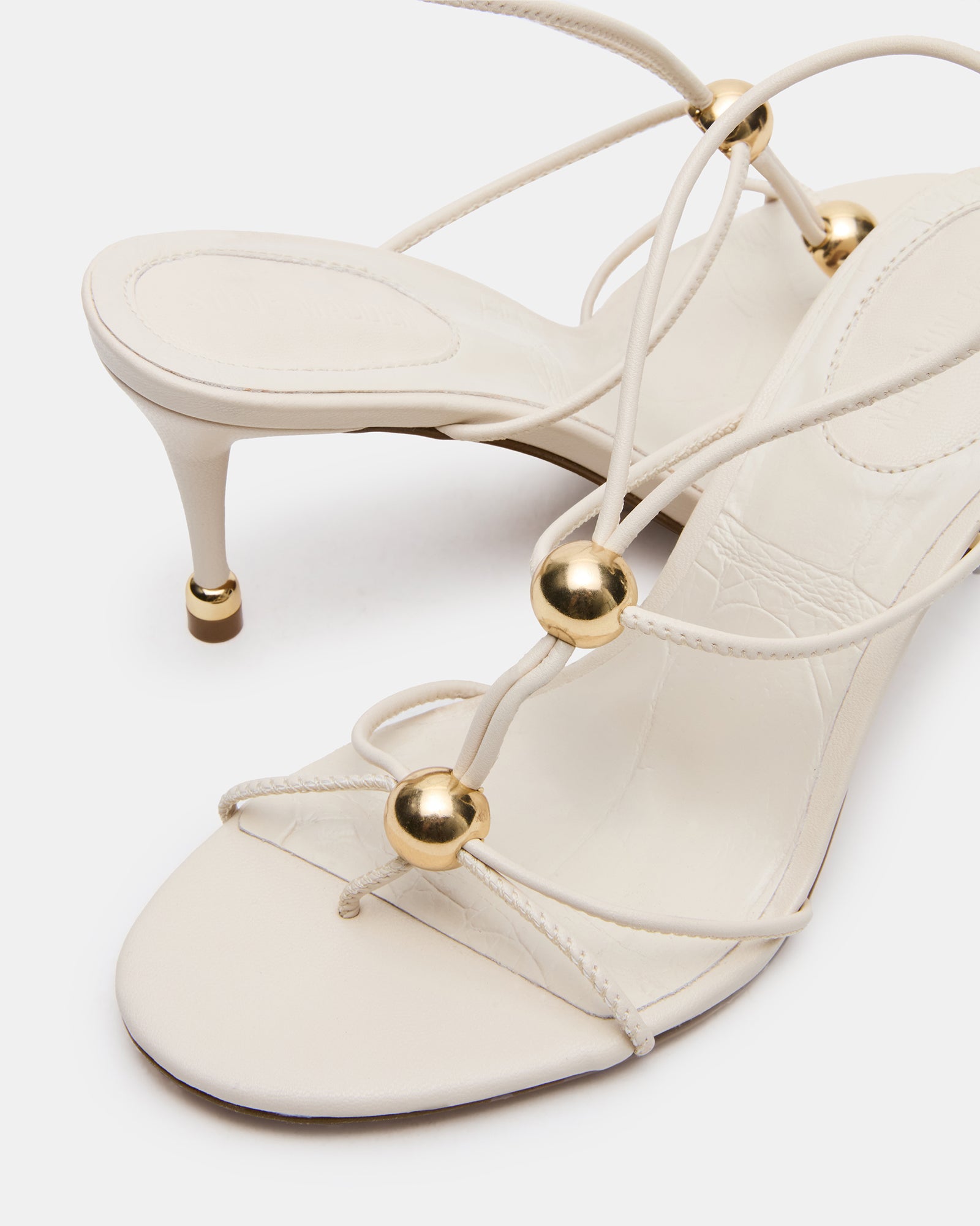 White heels with stunning gold hardware, ideal for formal occasions.