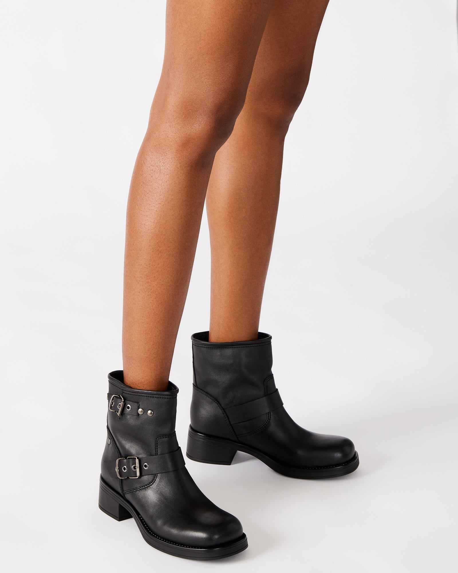 Side view of black ankle boots styled with jeans for daily urban wear