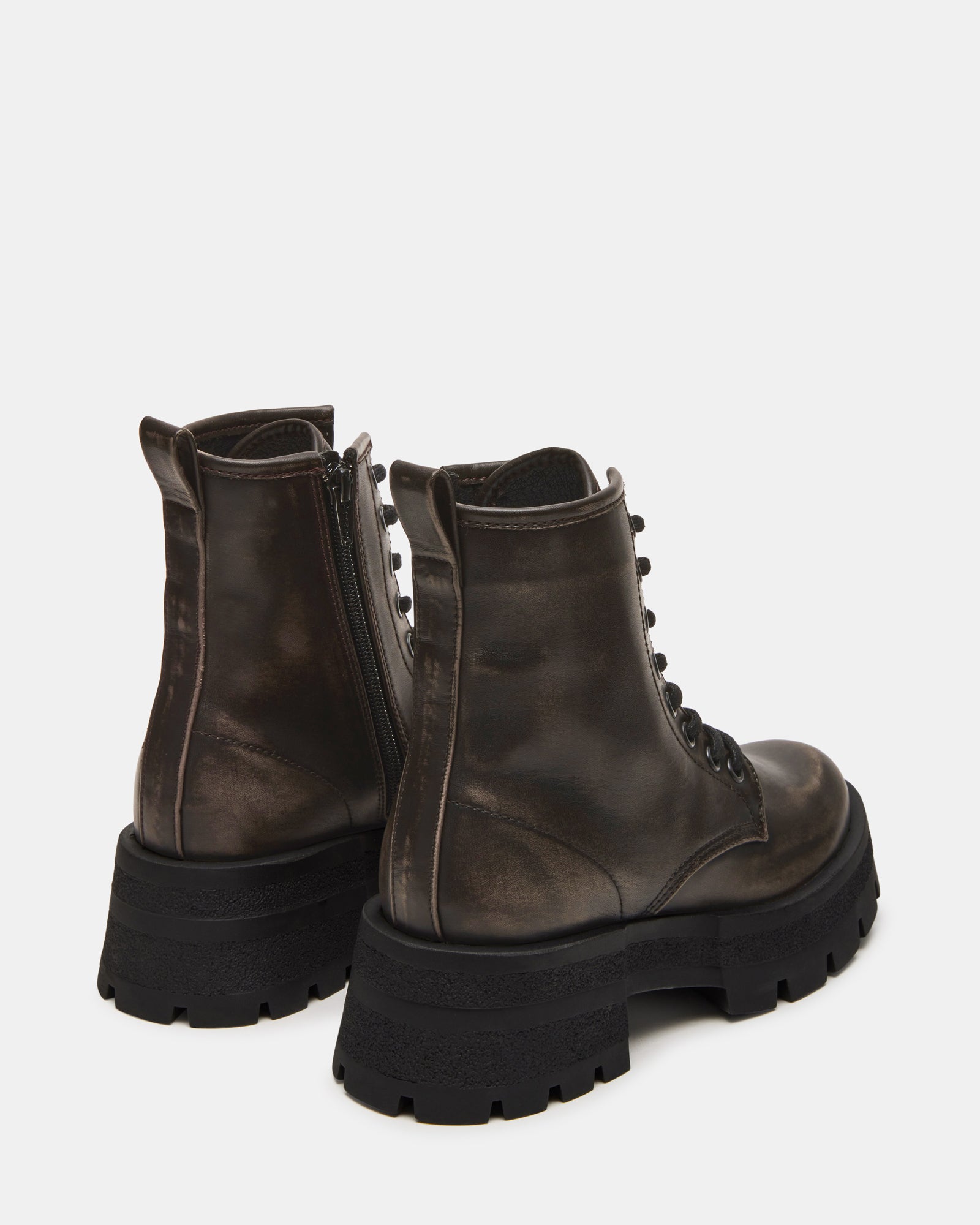 Combat boots men variant shown beside womens pair for size reference on outdoor bench