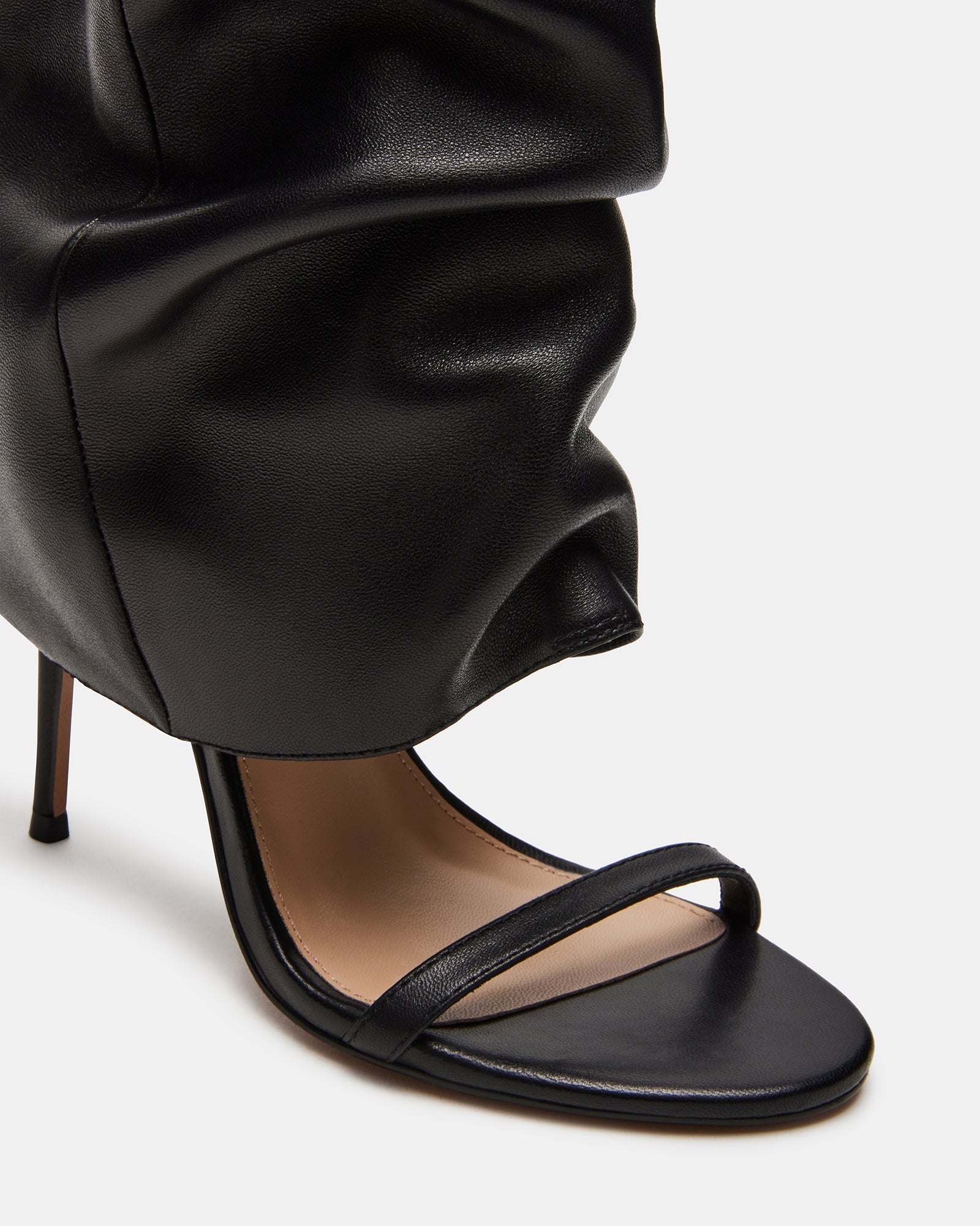 Black knee-high stiletto boot from the side, showcasing its elegant design.