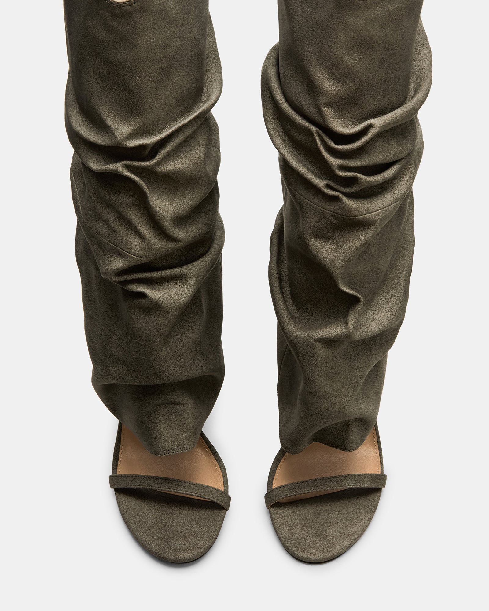 Grey distressed knee-high boots with open toe and stiletto heel on a models foot