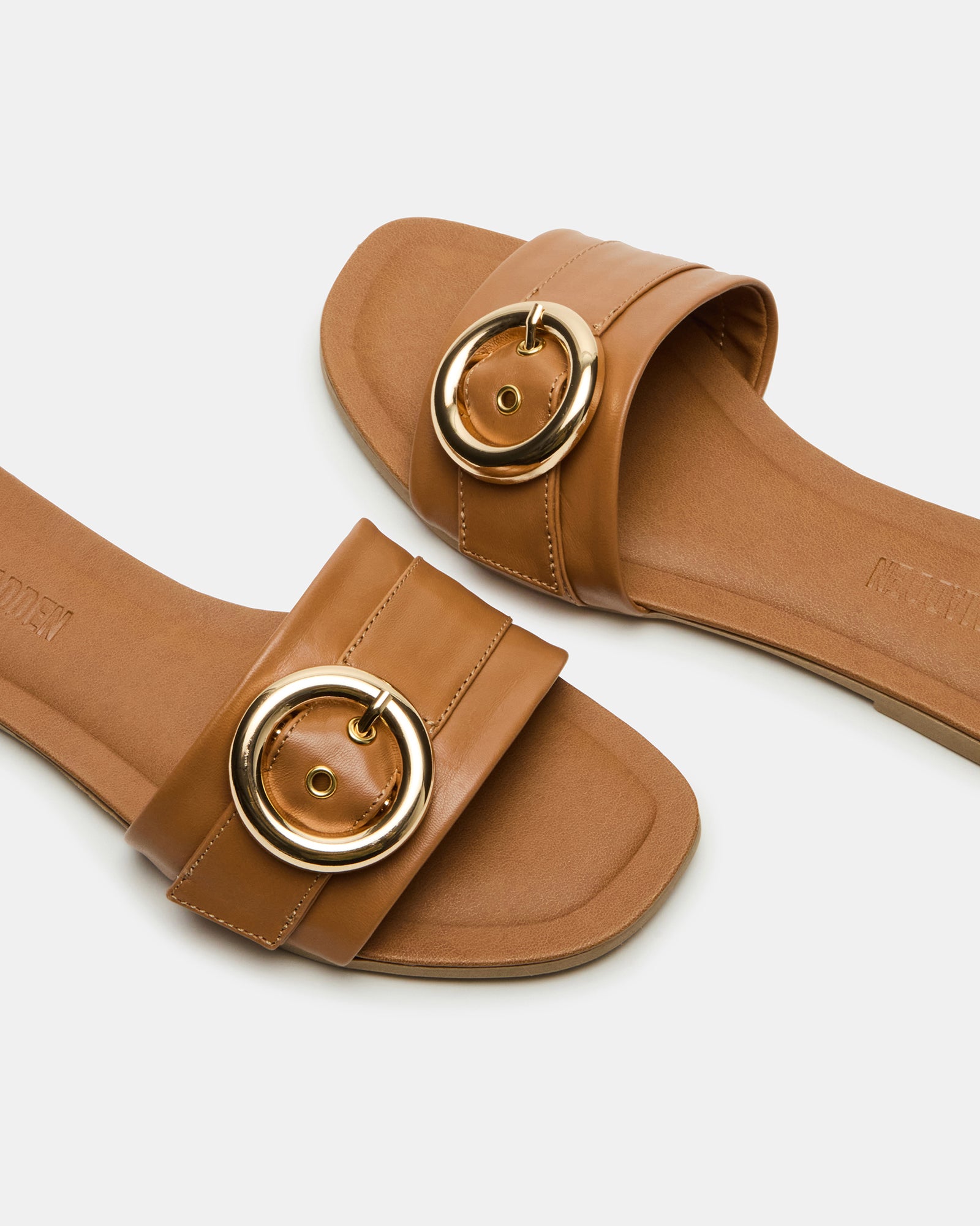 Close-up of REEF tan leather sandals showing buckle detail