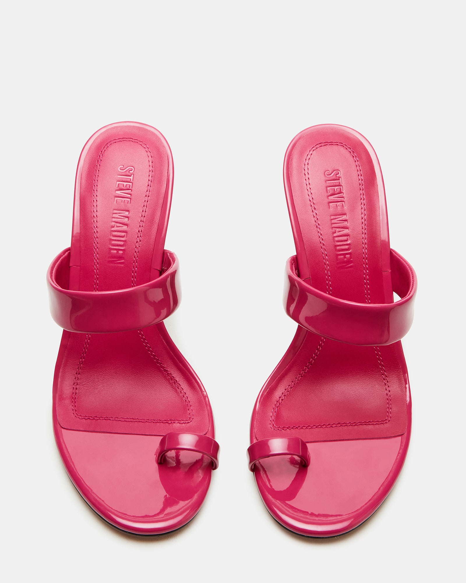 Side profile of fuchsia shoes with 3.75 inch mule heel against a minimalist backdrop