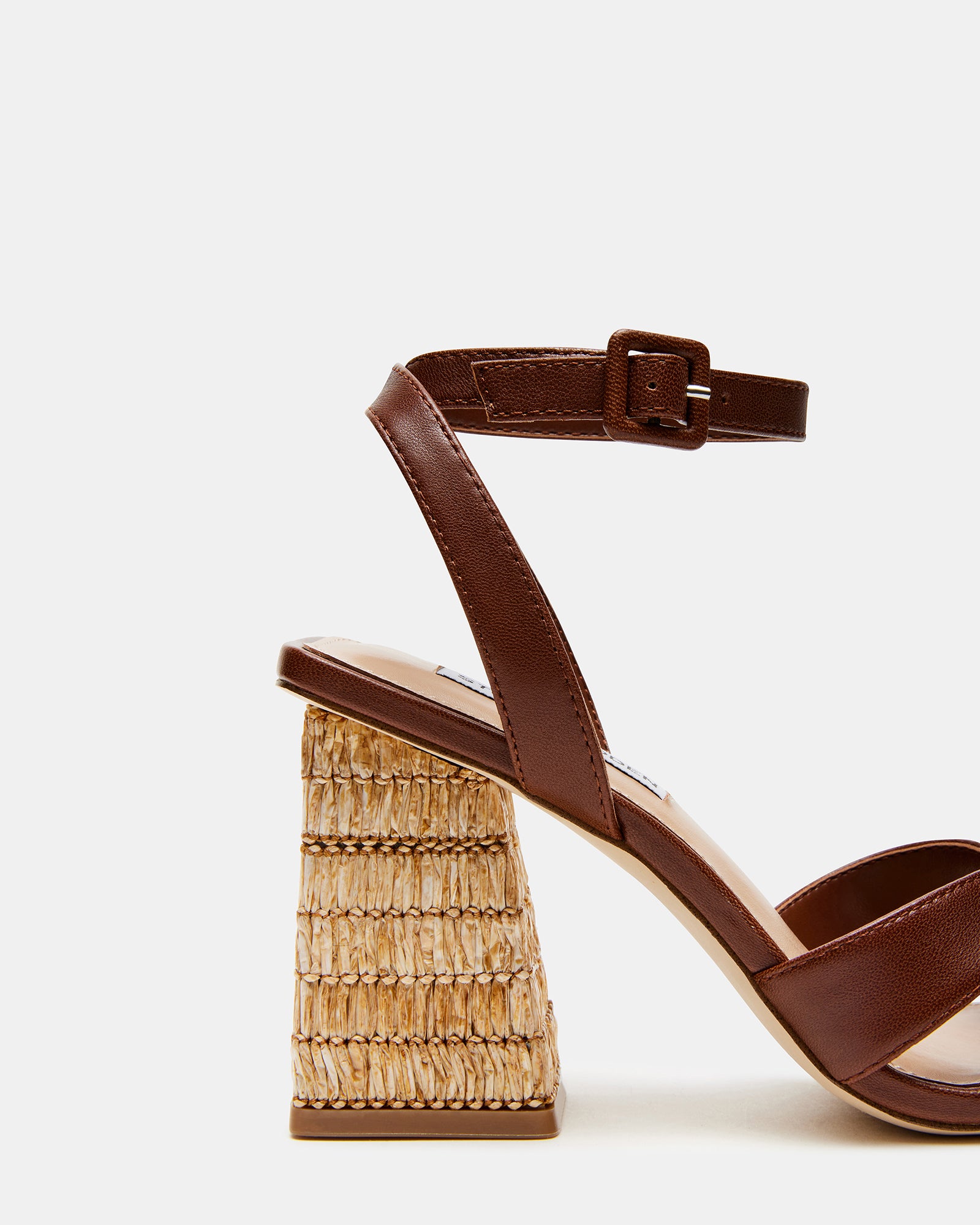 Close-up of the criss-cross straps on brown leather sandals.