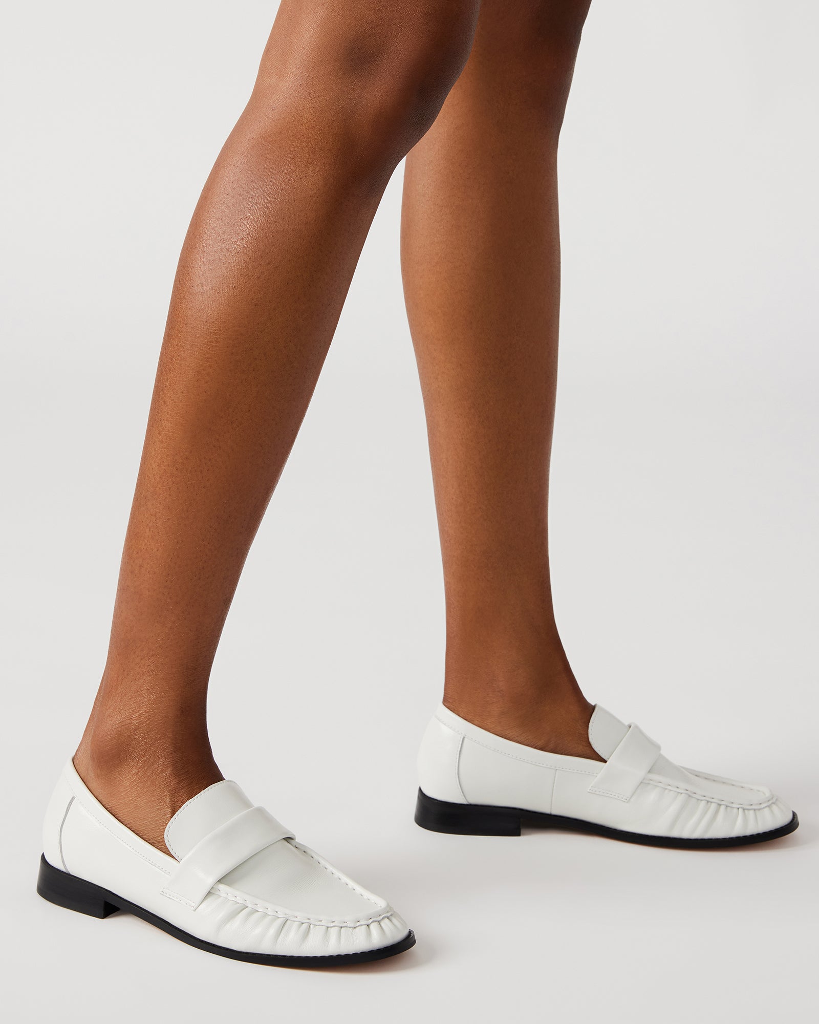 Close-up of the leather upper and synthetic sole of mens penny loafers