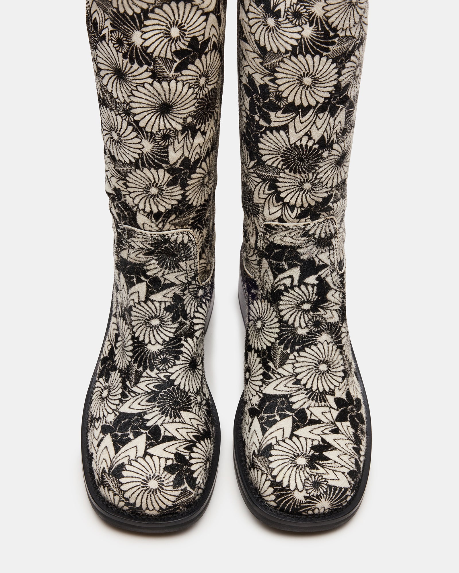 Riggs Black Multi knee-high boots paired with jeans for a chic urban look.