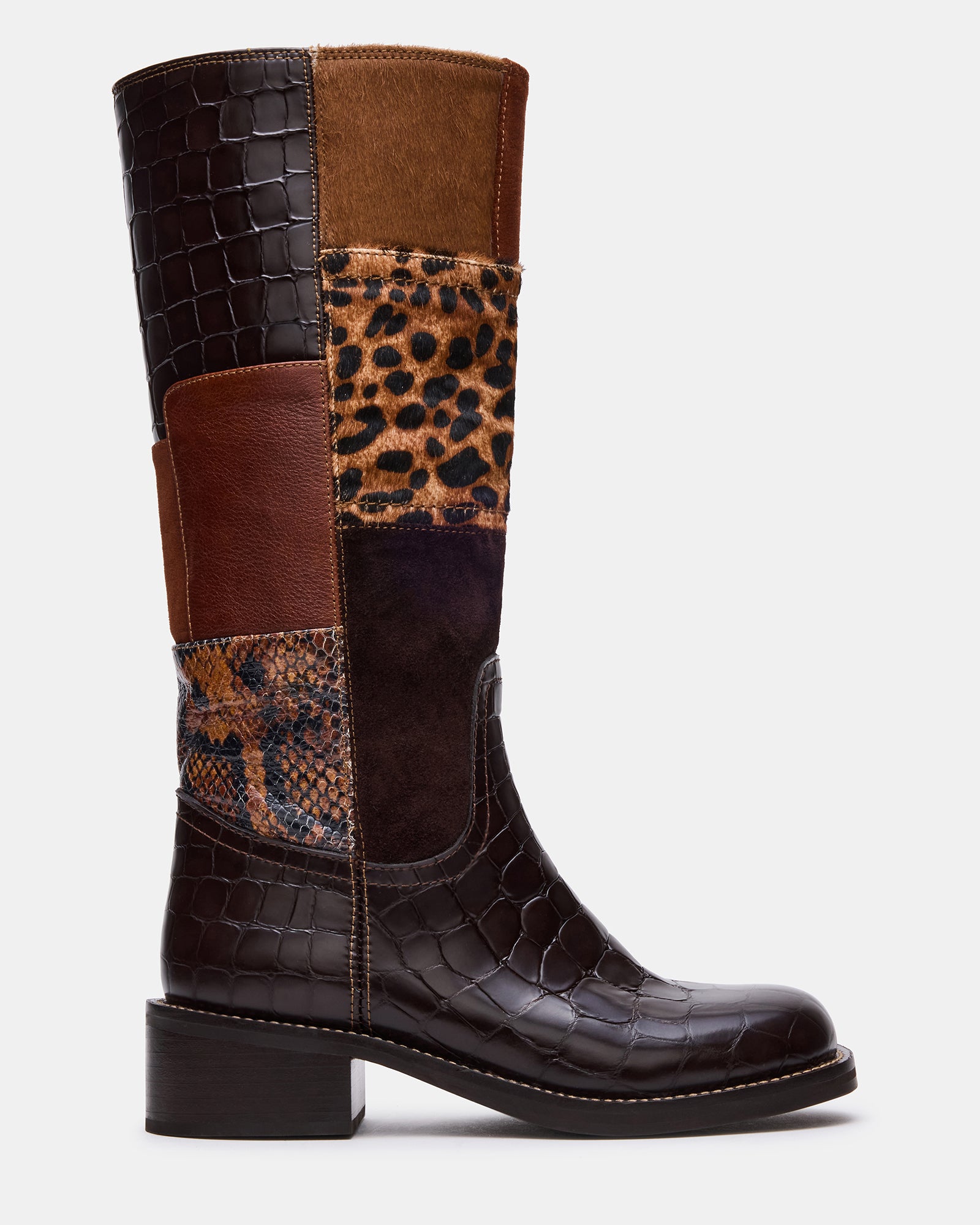 Side angle of fashion boots with suede and leather blend against city backdrop