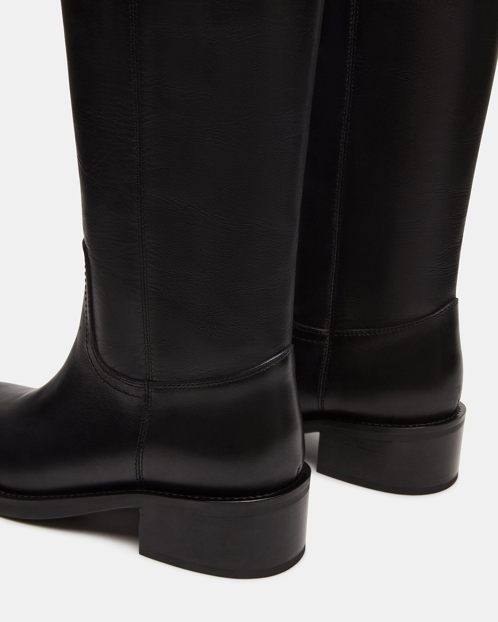 Side view of RIGGS black leather knee-high boots highlighting the sleek design
