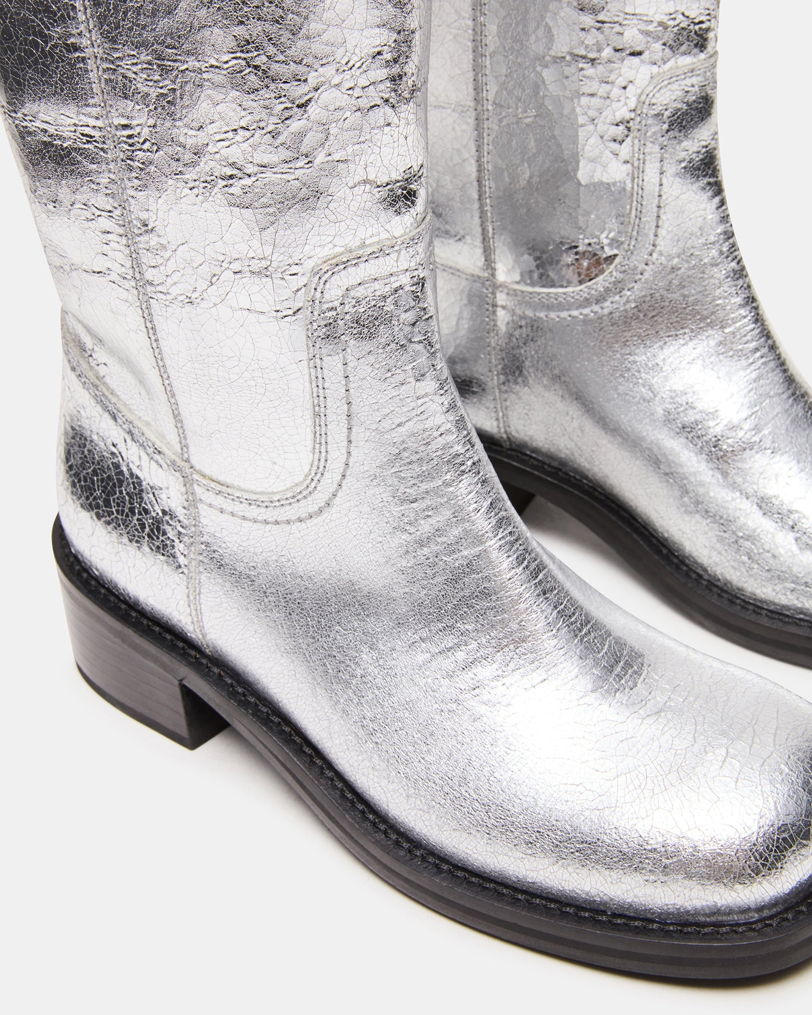Full view of the silver leather cowboy boots worn with casual jeans for a modern Western look