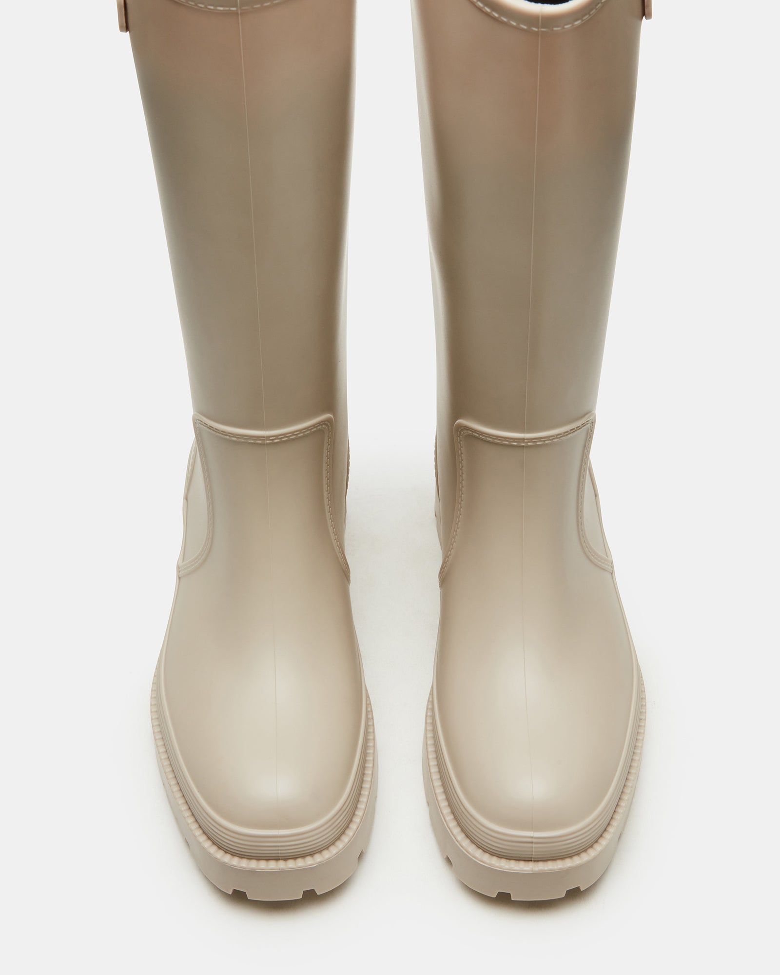RockyH2O Bone rain boots displayed on a wet cobblestone path