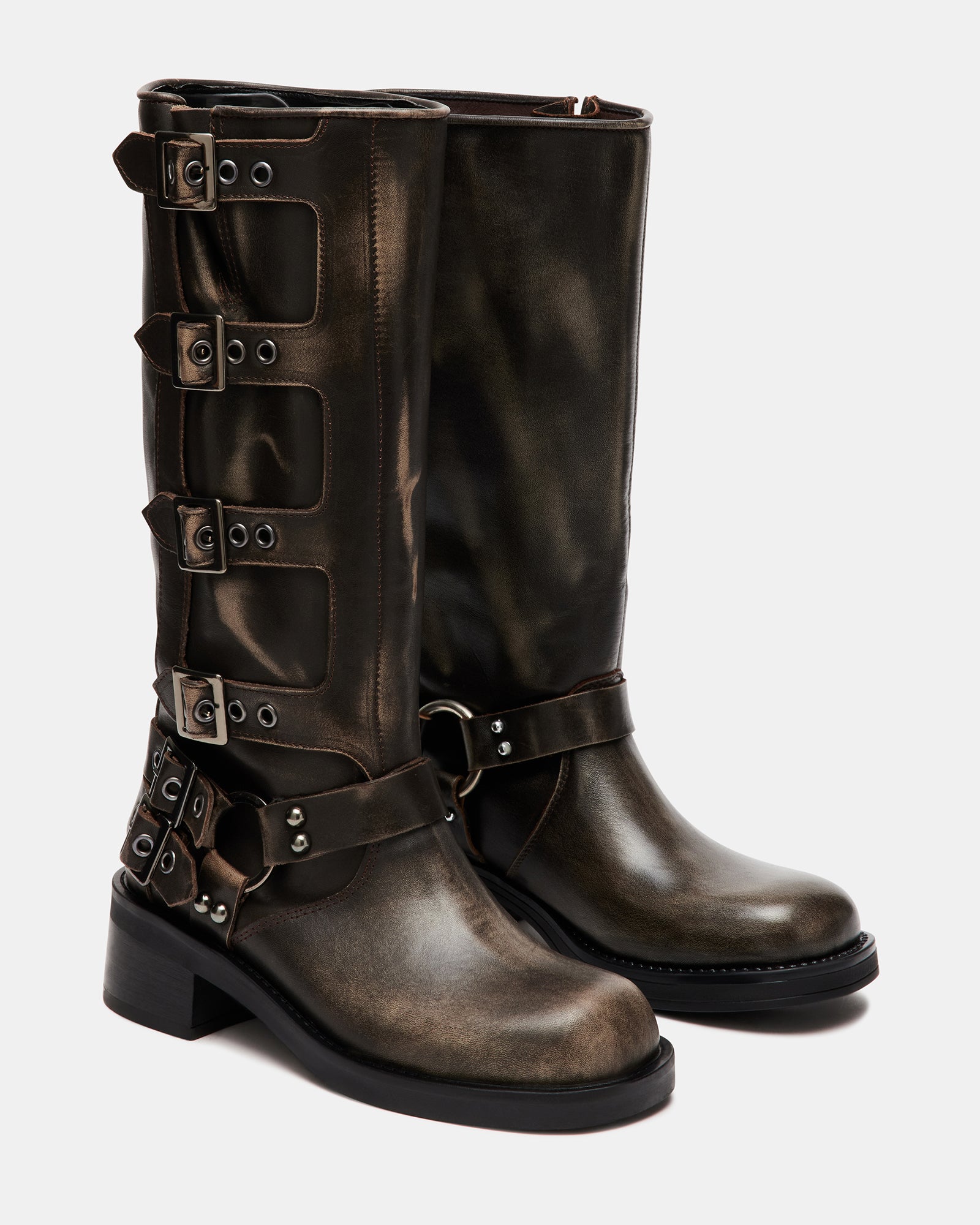 Model walking in distressed leather knee boots in city street