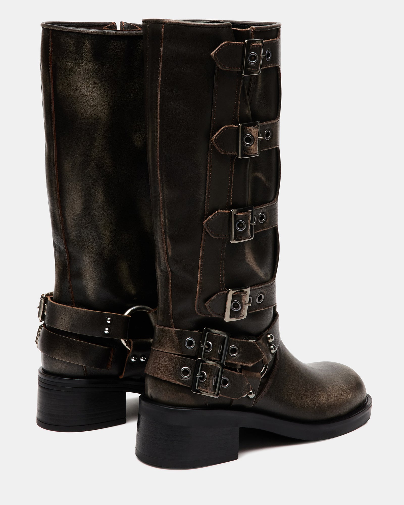 Model walking in distressed leather knee boots in city street