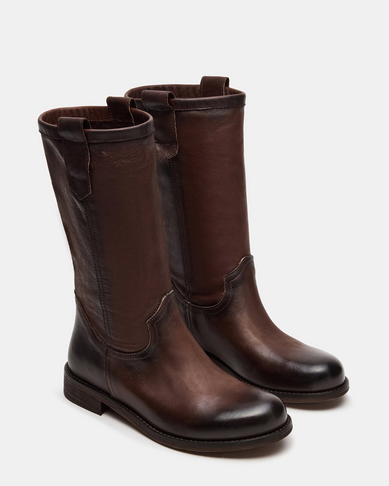 Womens brown leather boots worn outdoors on autumn sidewalk