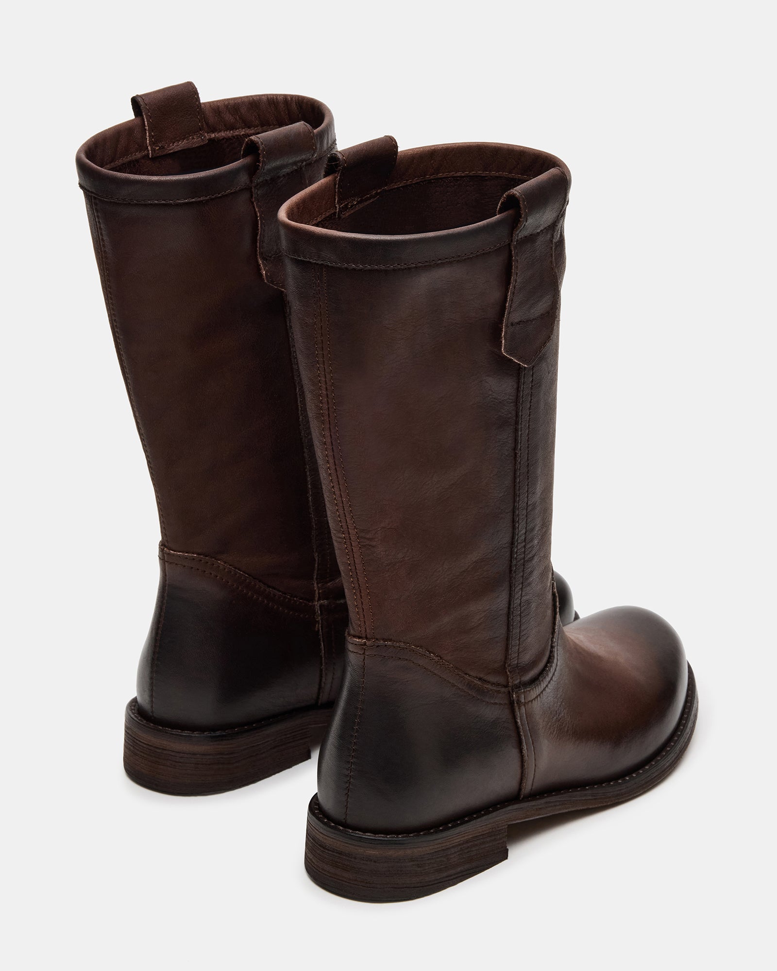 Womens brown leather boots worn outdoors on autumn sidewalk