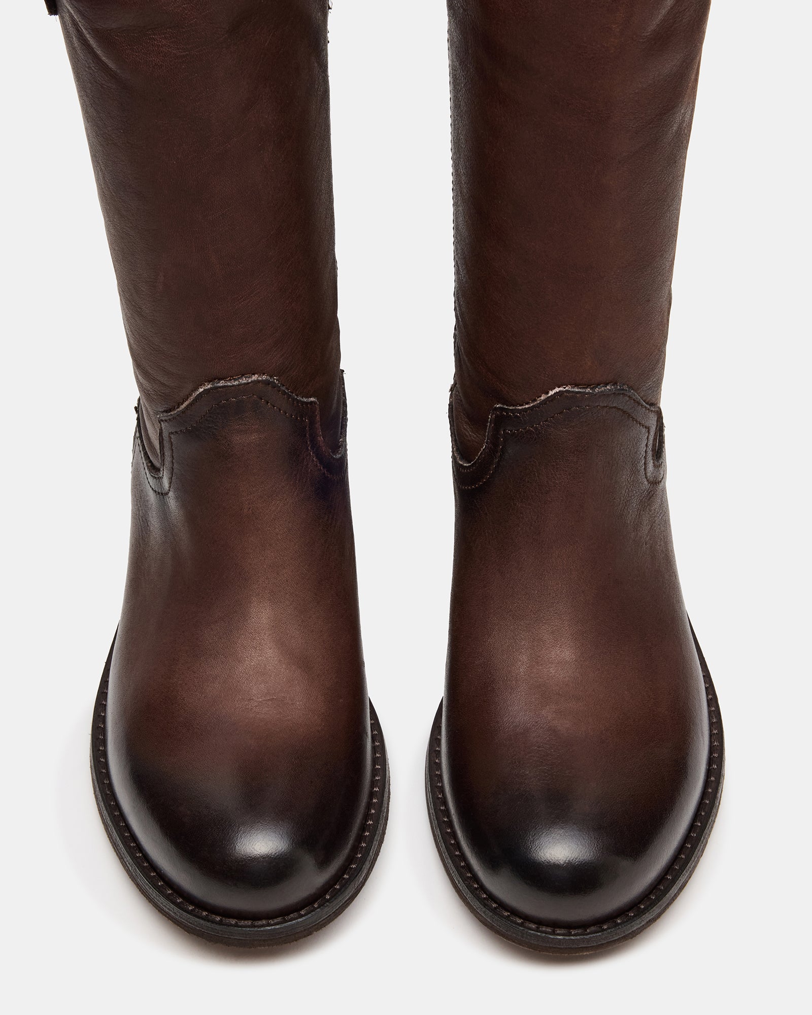 Side view of brown leather knee high boots styled with winter jeans