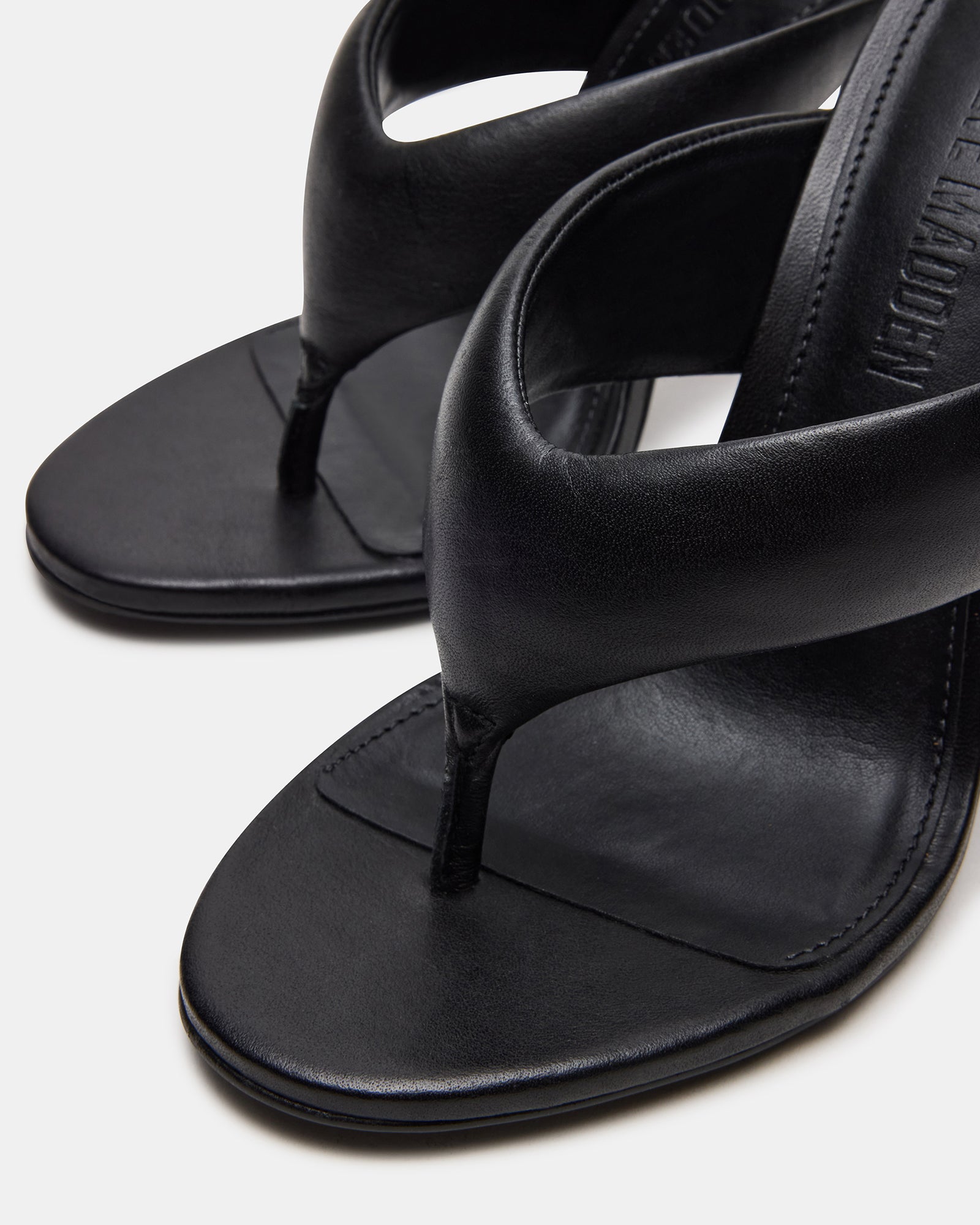 Black high heel mules worn casually with a chic outfit.