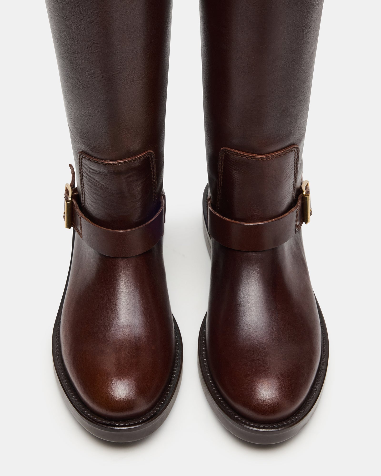 Side view of womens brown leather knee-high boots featuring adjustable buckles.
