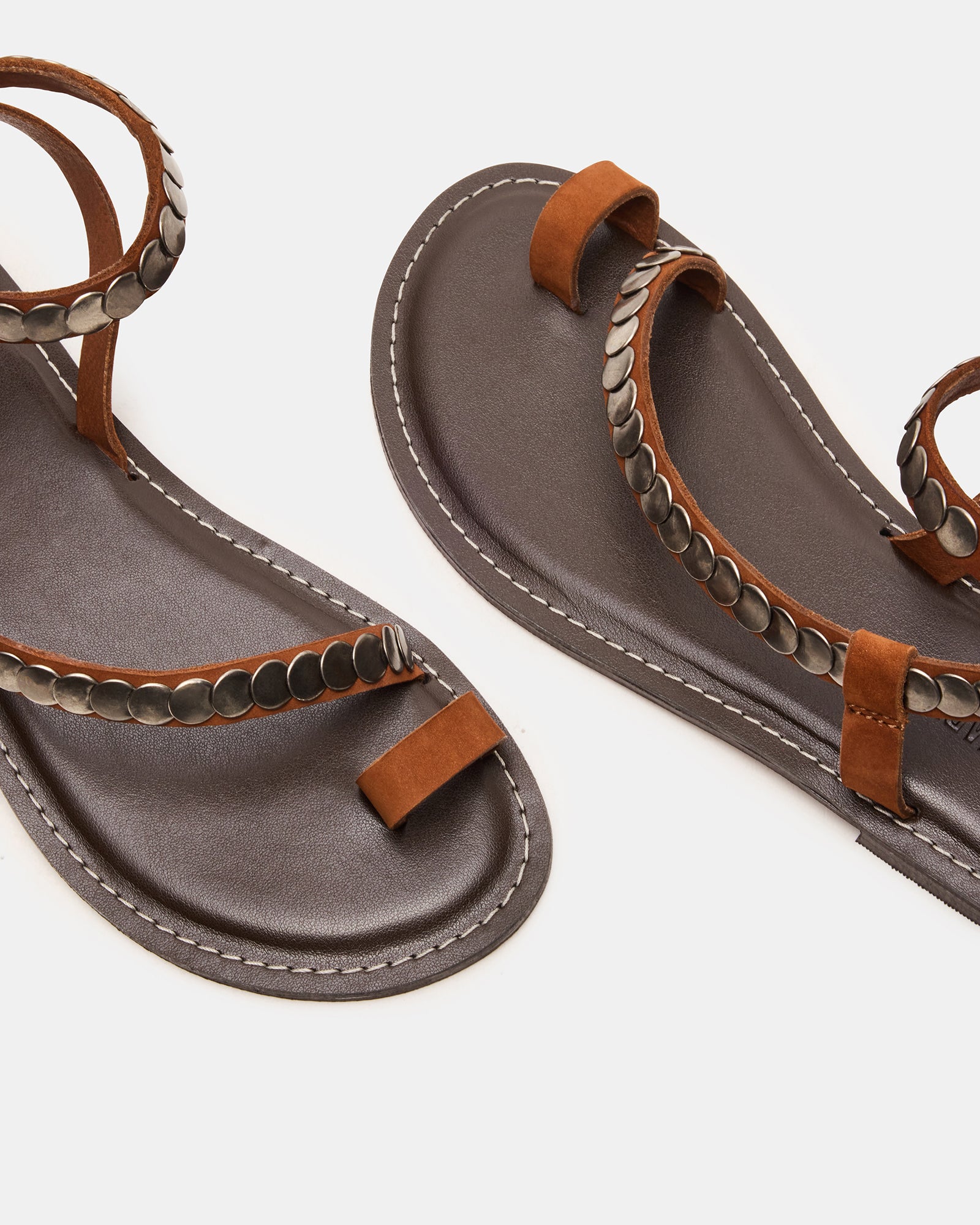 Close-up on white flat sandals walking through city streets