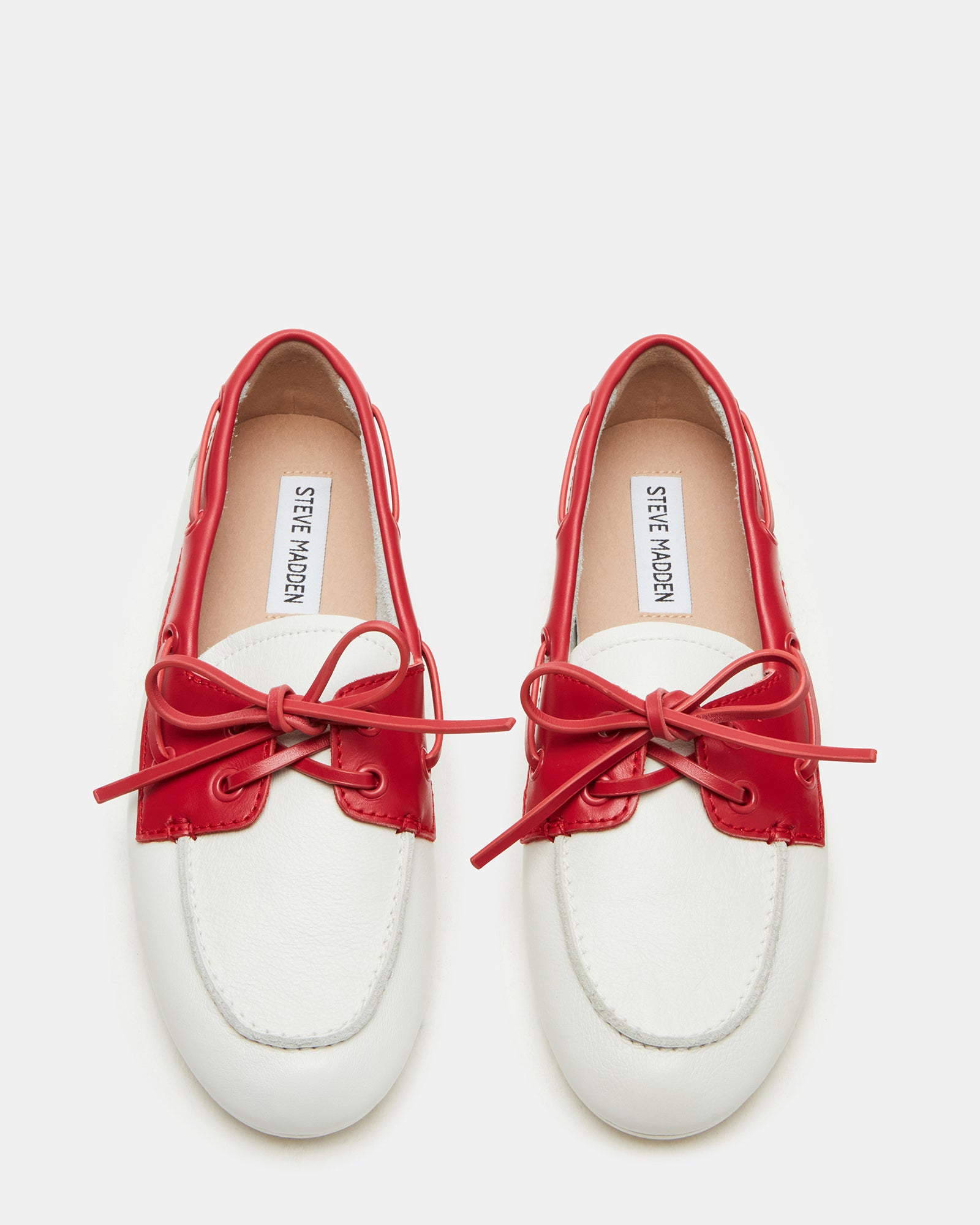 Front view of red leather loafers on a wooden surface.