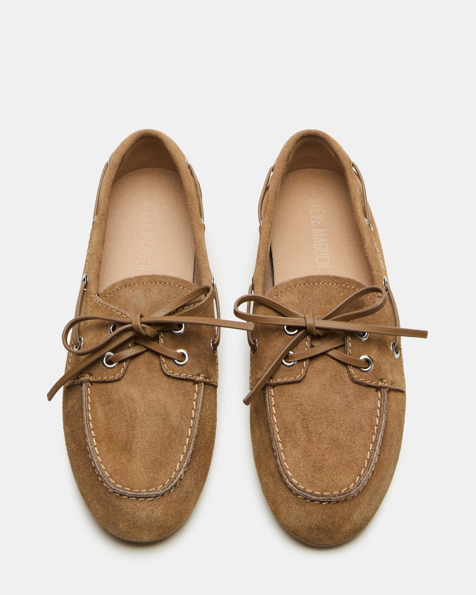 Side view of taupe suede loafers on hardwood floor