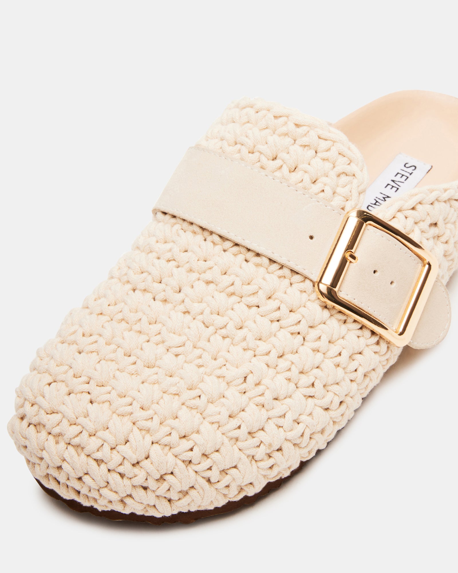 Side view of Timeless Knit Cream Clogs showcasing the woven upper and buckle strap.