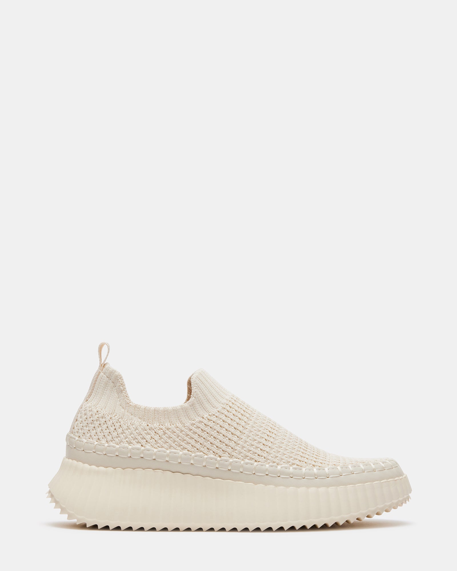 Side view of sleek beige slip-on platform sneakers on a casual outing.