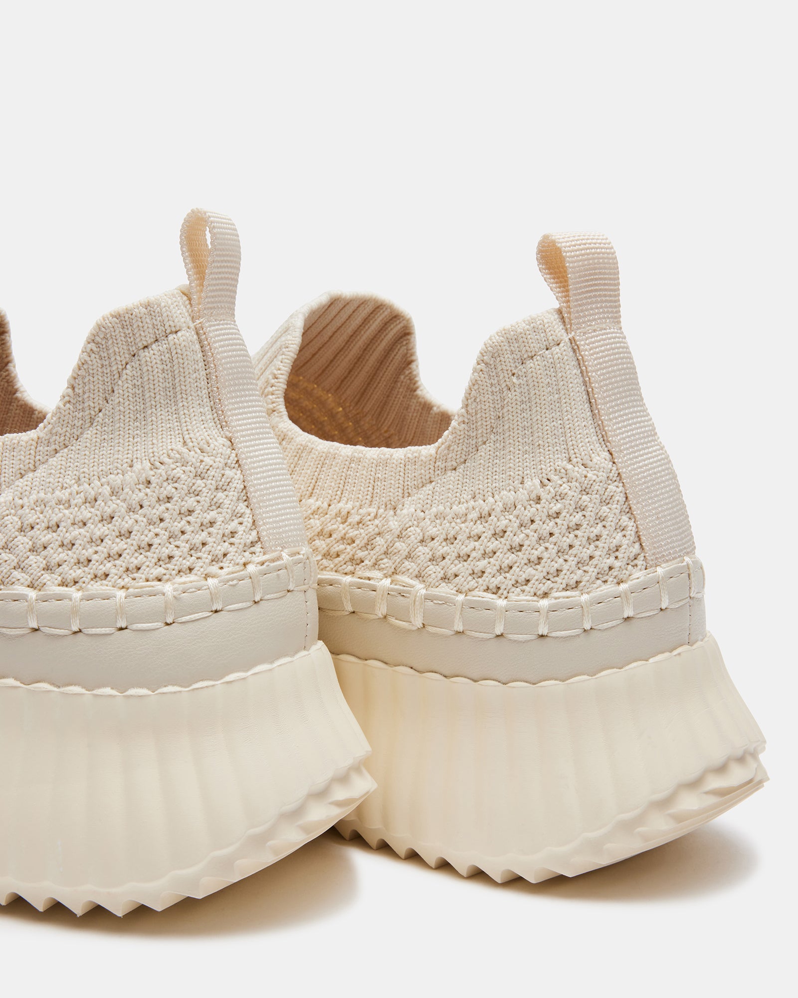 Side view of sleek beige slip-on platform sneakers on a casual outing.