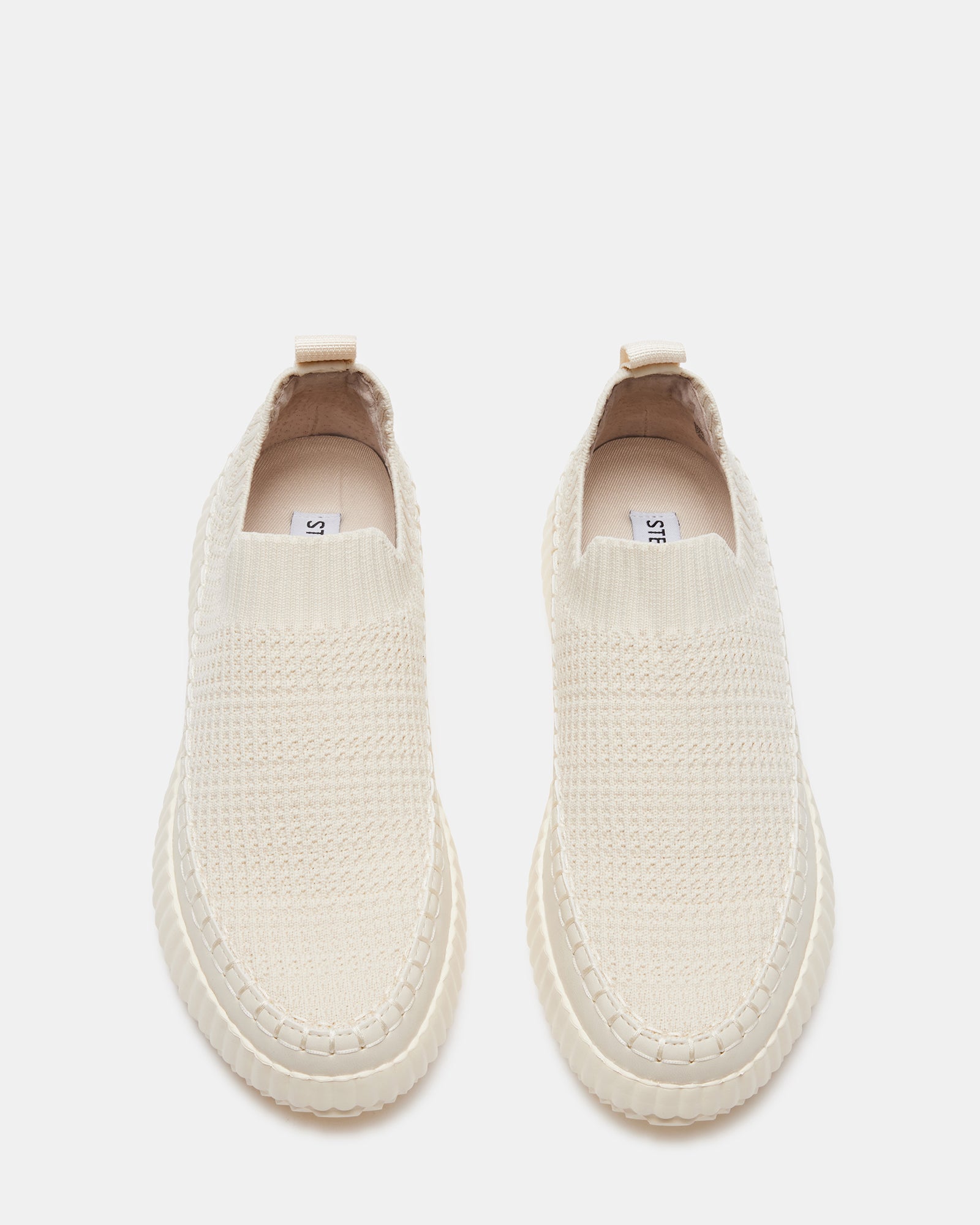 Close-up of the waffle weave texture on beige slip-on sneakers.