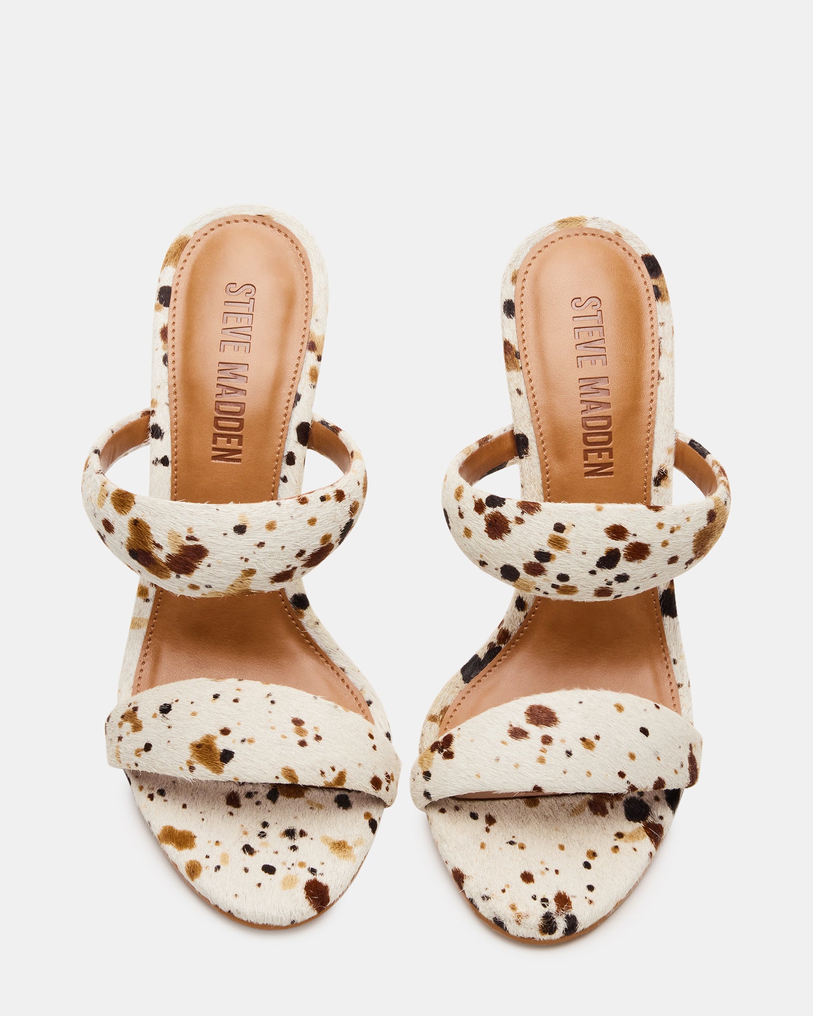 Side view of Saturn cow print heels highlighting the tubular double strap