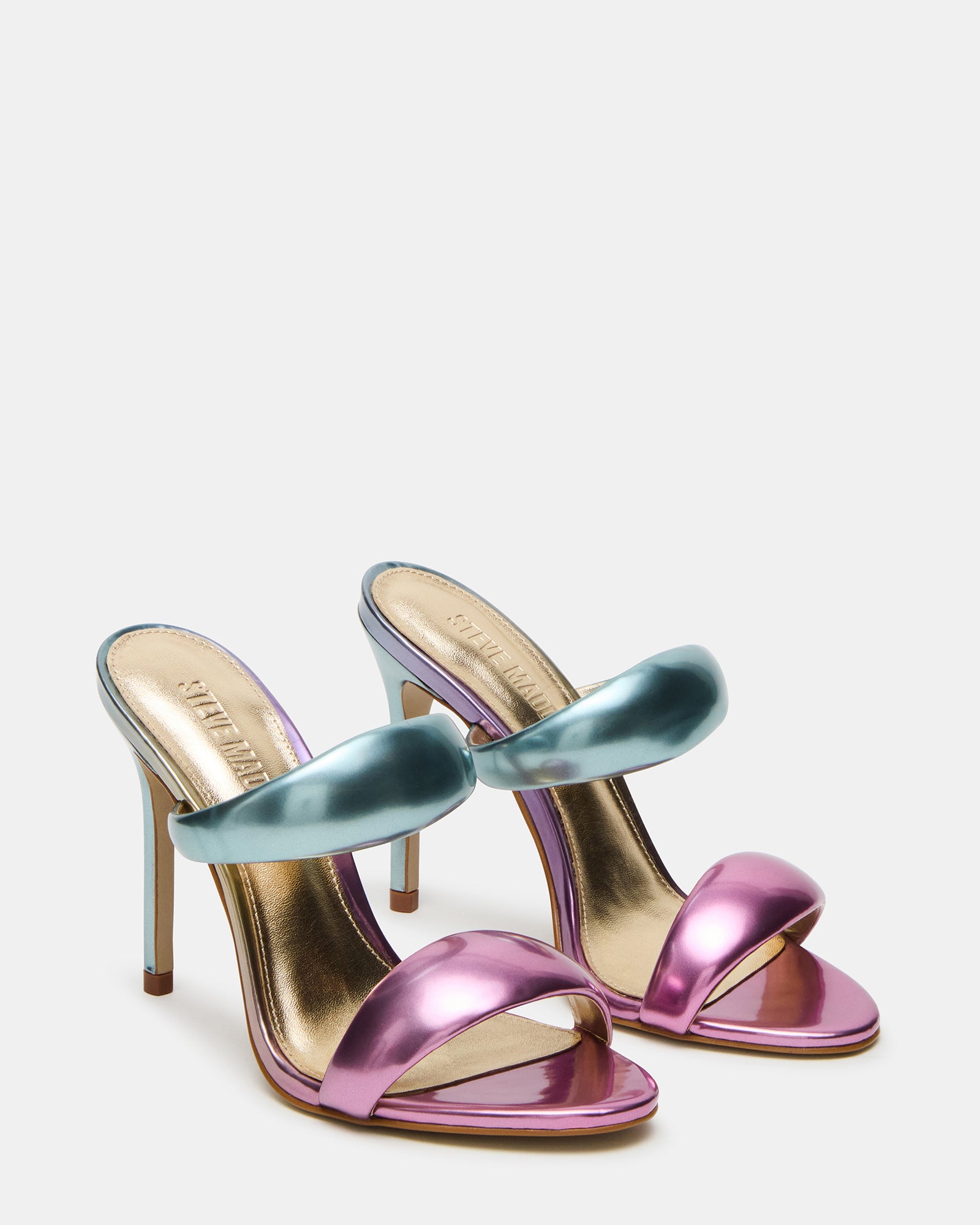 Profile shot of white mule high heels styled on a minimalist backdrop
