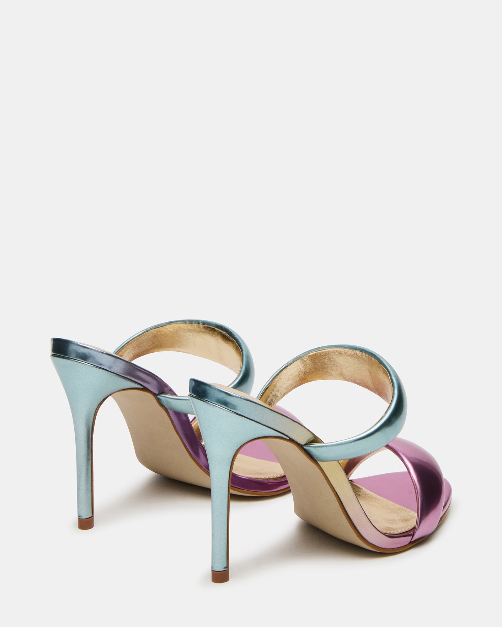 Profile shot of white mule high heels styled on a minimalist backdrop