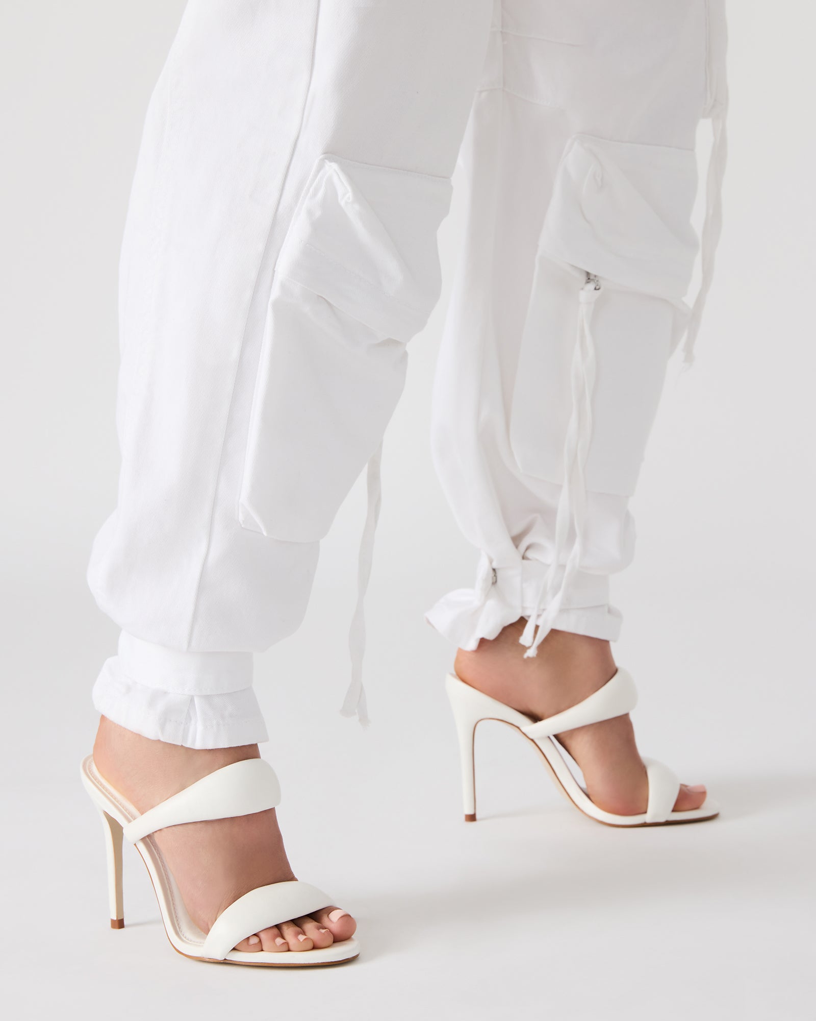 Close-up of stiletto heel on Luxe Saturn White Mule Heels.