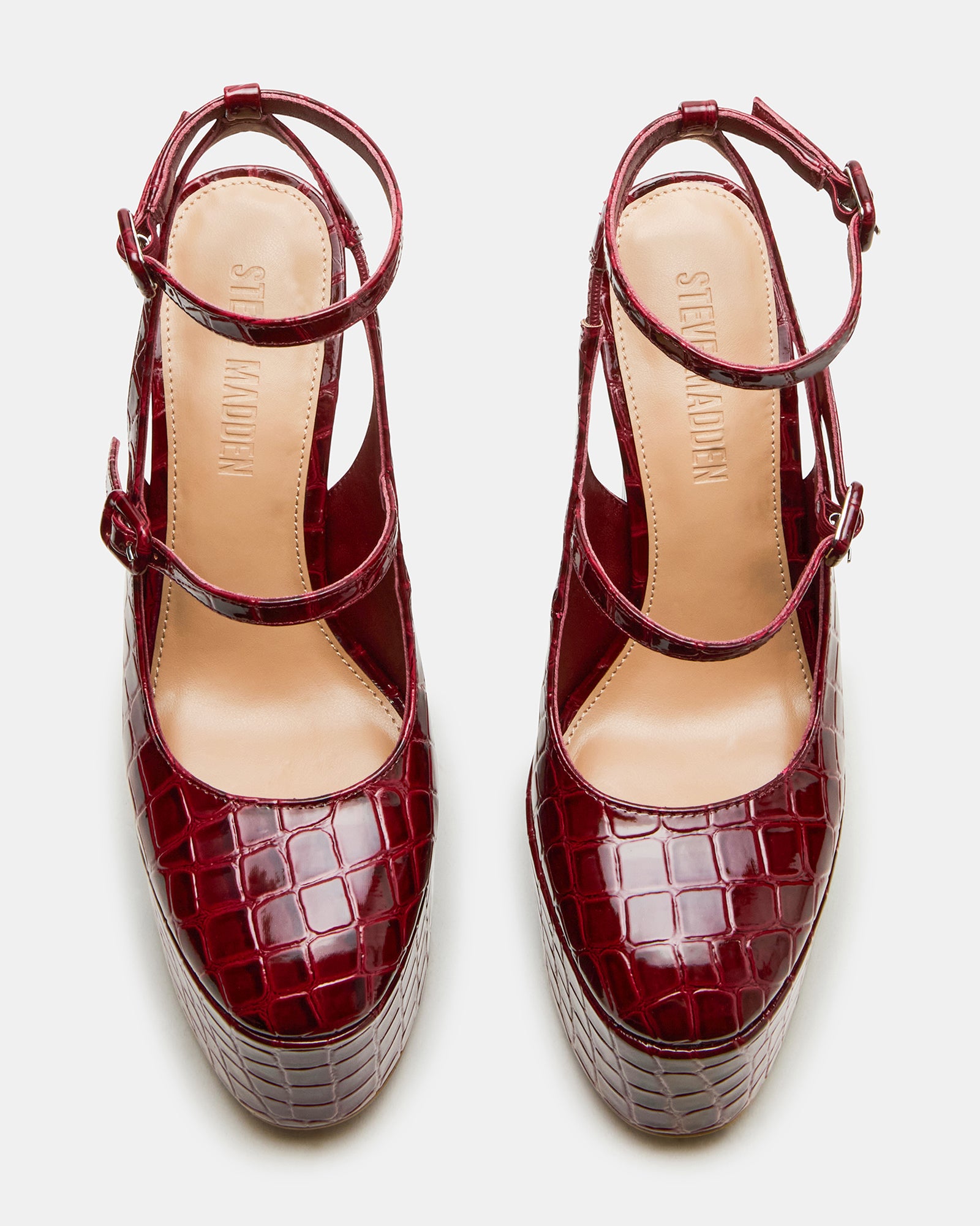 Close-up of the ankle strap on chic red platform sandals.