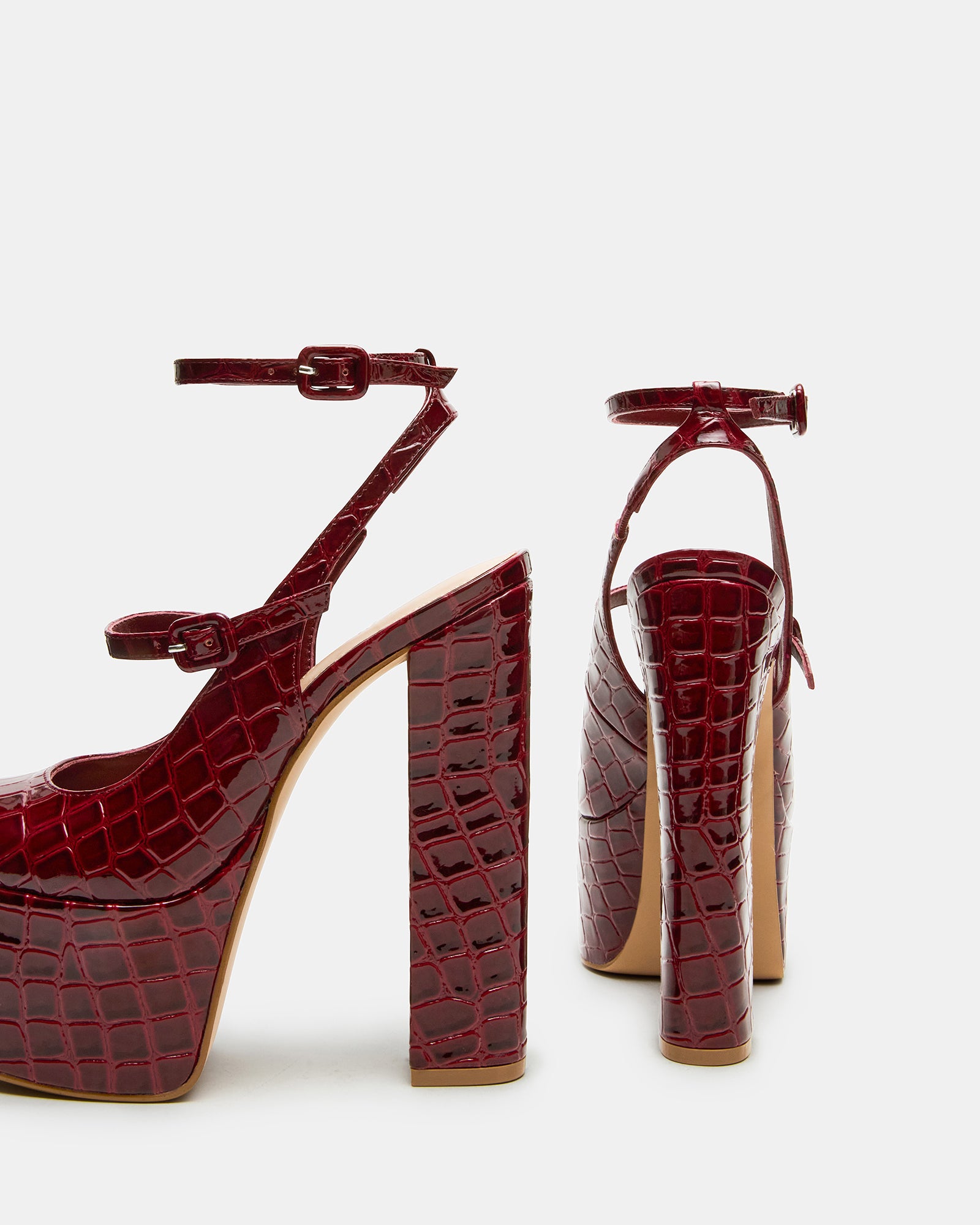 Elegant red platform heels showcasing strappy design from the side.
