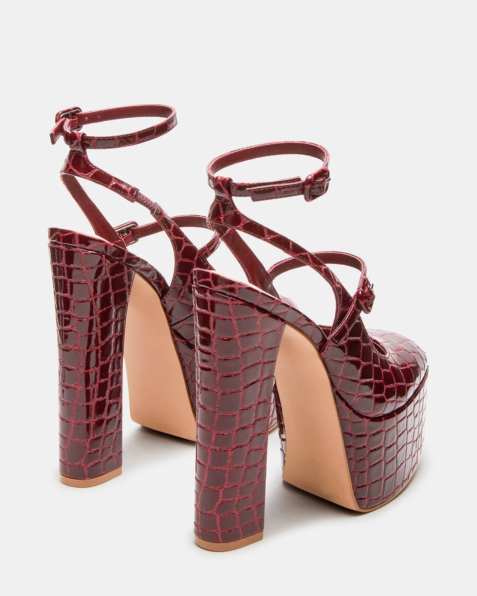 Model wearing red platform heels paired with a stylish outfit.