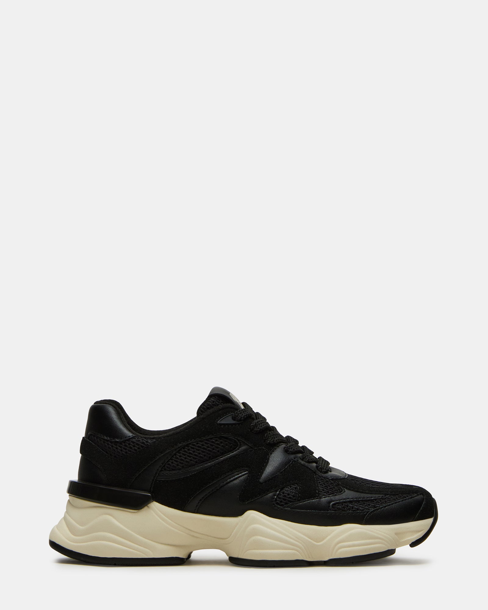 Side view of SEBI BLACK low top sneakers styled with casual denim for a Brooklyn weekend look.