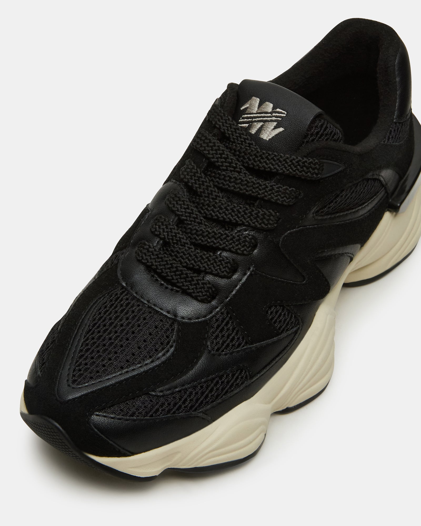 Side view of SEBI BLACK low top sneakers styled with casual denim for a Brooklyn weekend look.