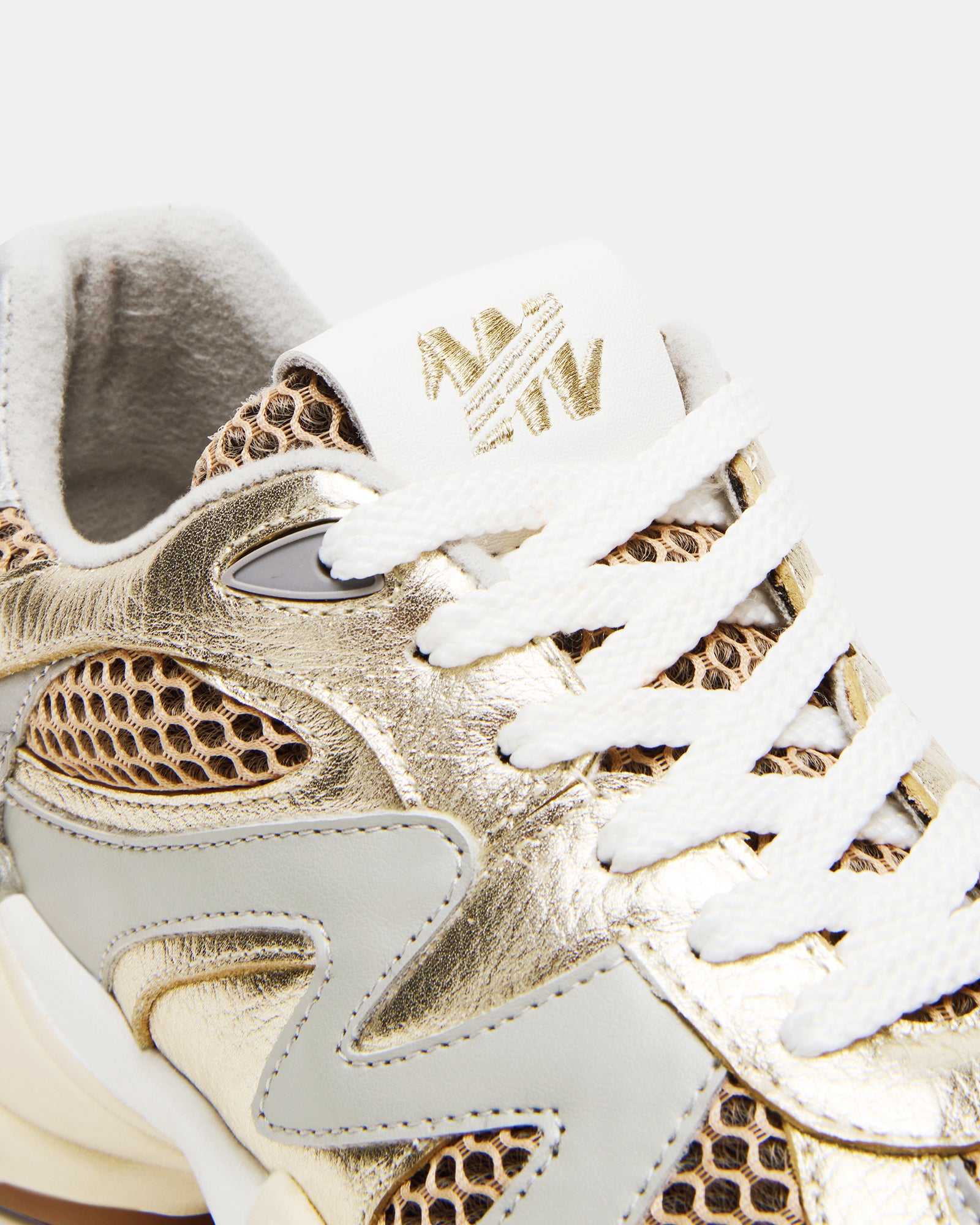 Side view of SEBI gold low top sneakers with lace-up detail