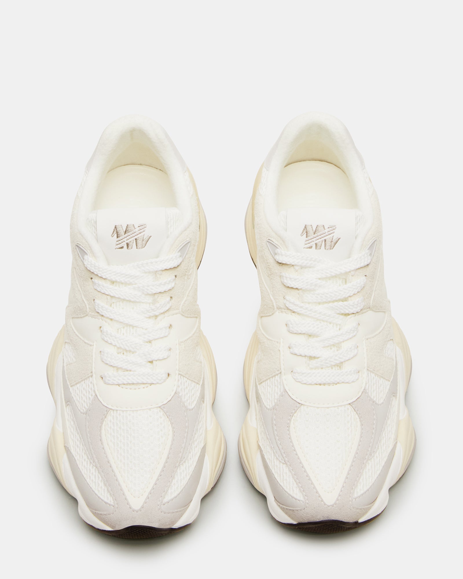 Close-up of white leather sneakers highlighting stitching and material texture