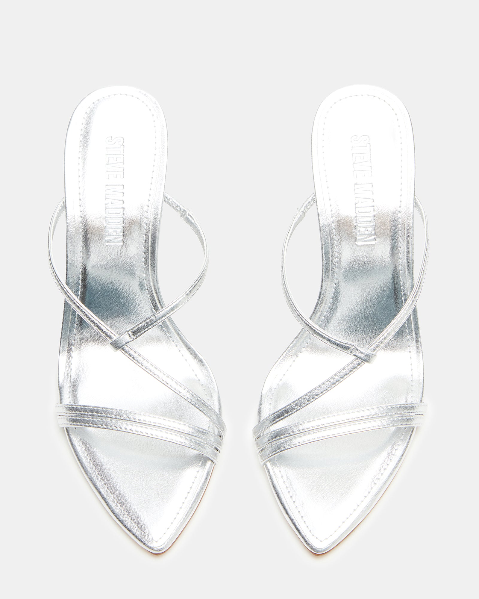 Silver strappy mule sandals worn with tailored trousers