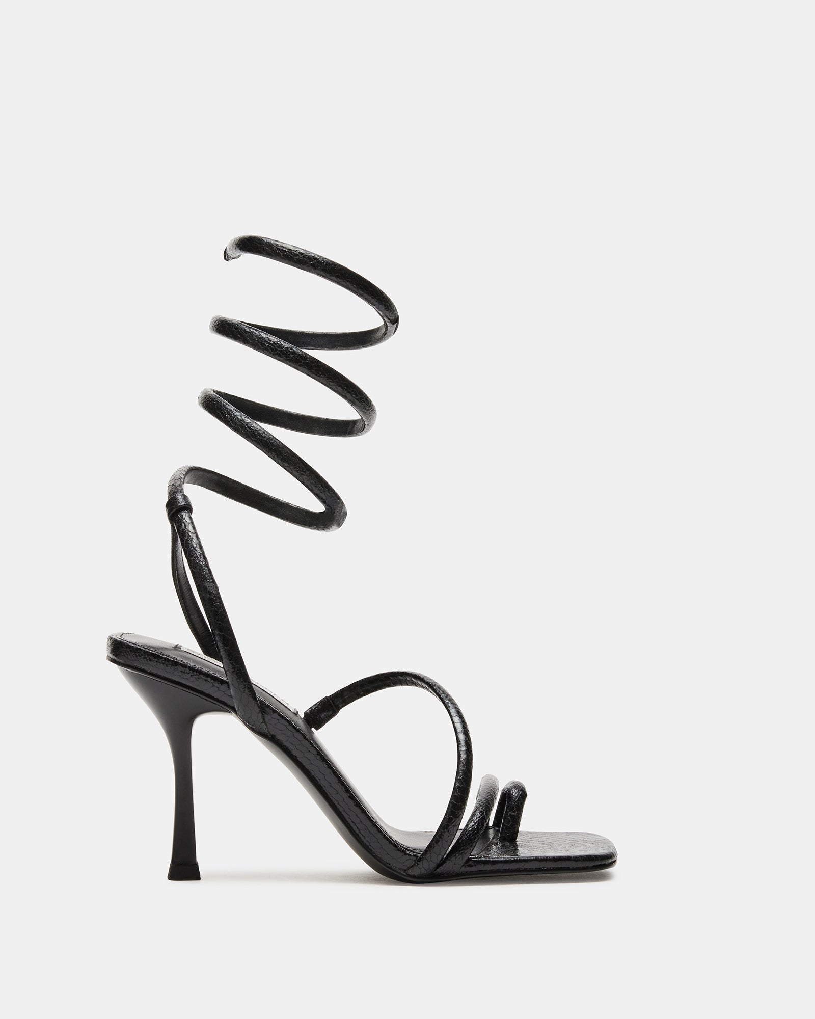 Black square toe stiletto sandal with coil ankle strap on a chic model