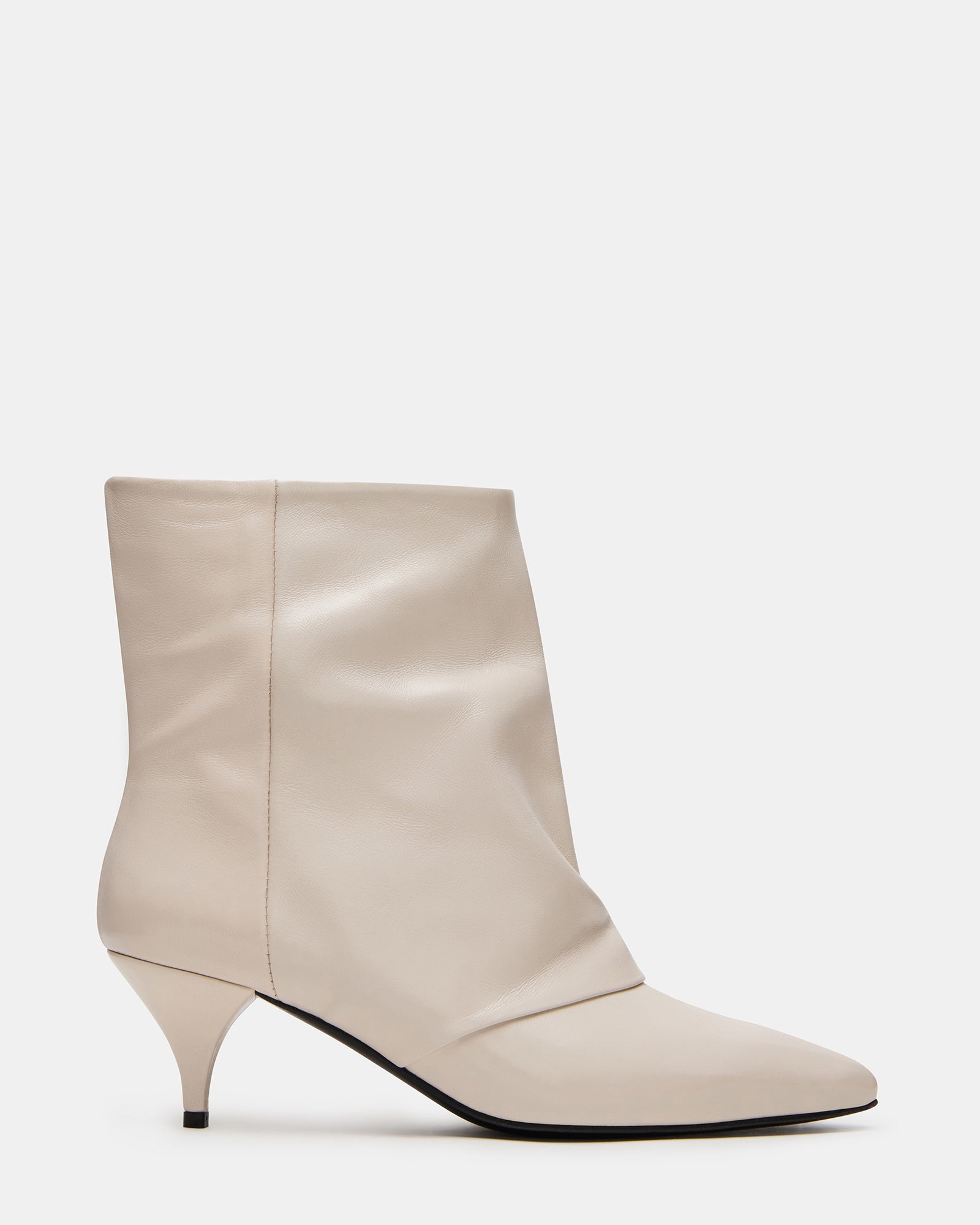 Close-up of white leather ankle boots showing pointed toe and kitten heel