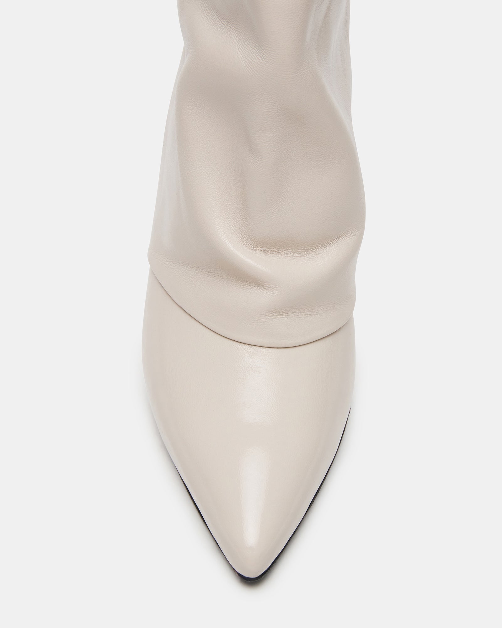 Close-up of white leather ankle boots showing pointed toe and kitten heel